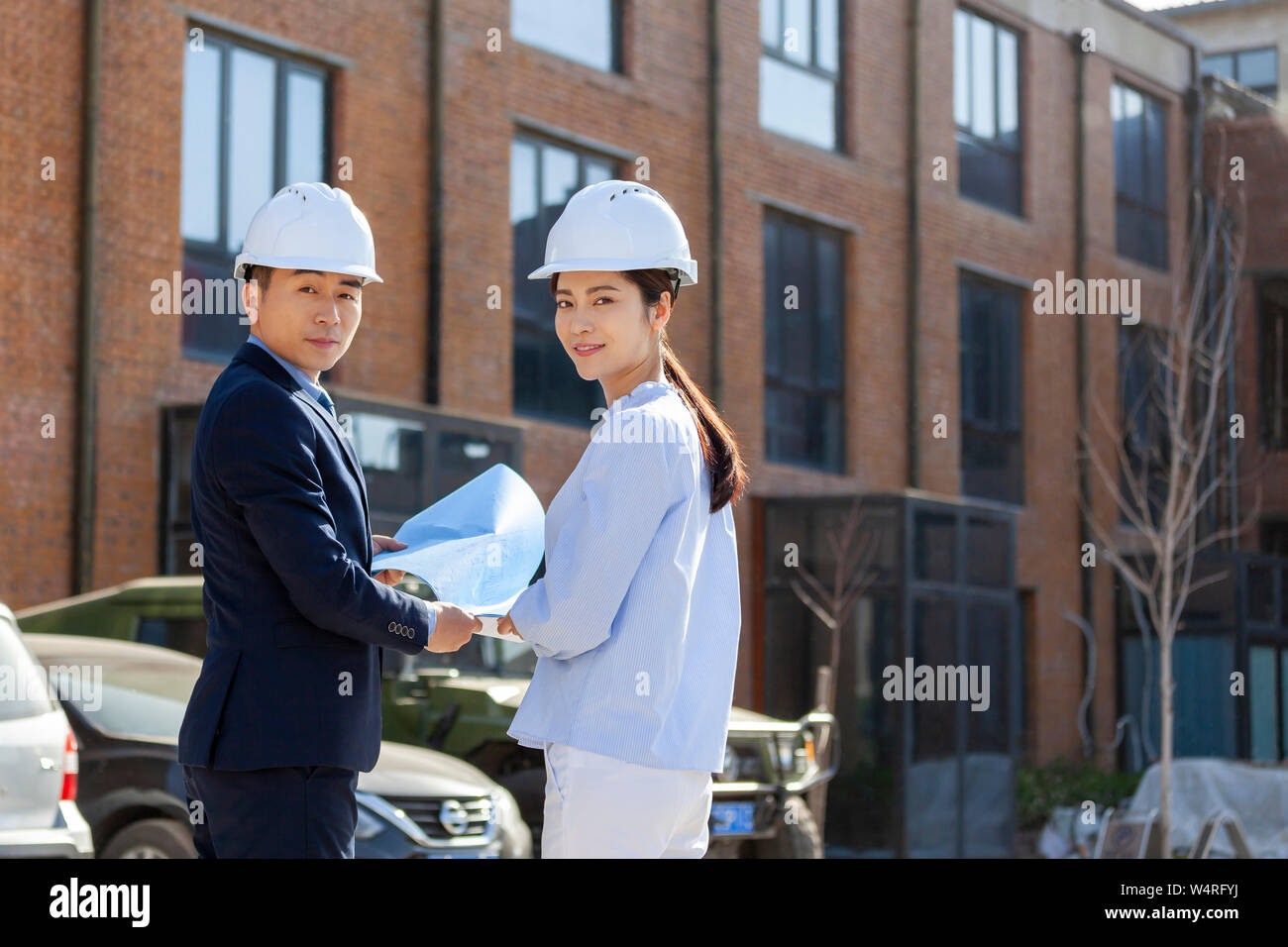 Due architetti che indossa caschi di sicurezza, Pechino, Cina Foto Stock
