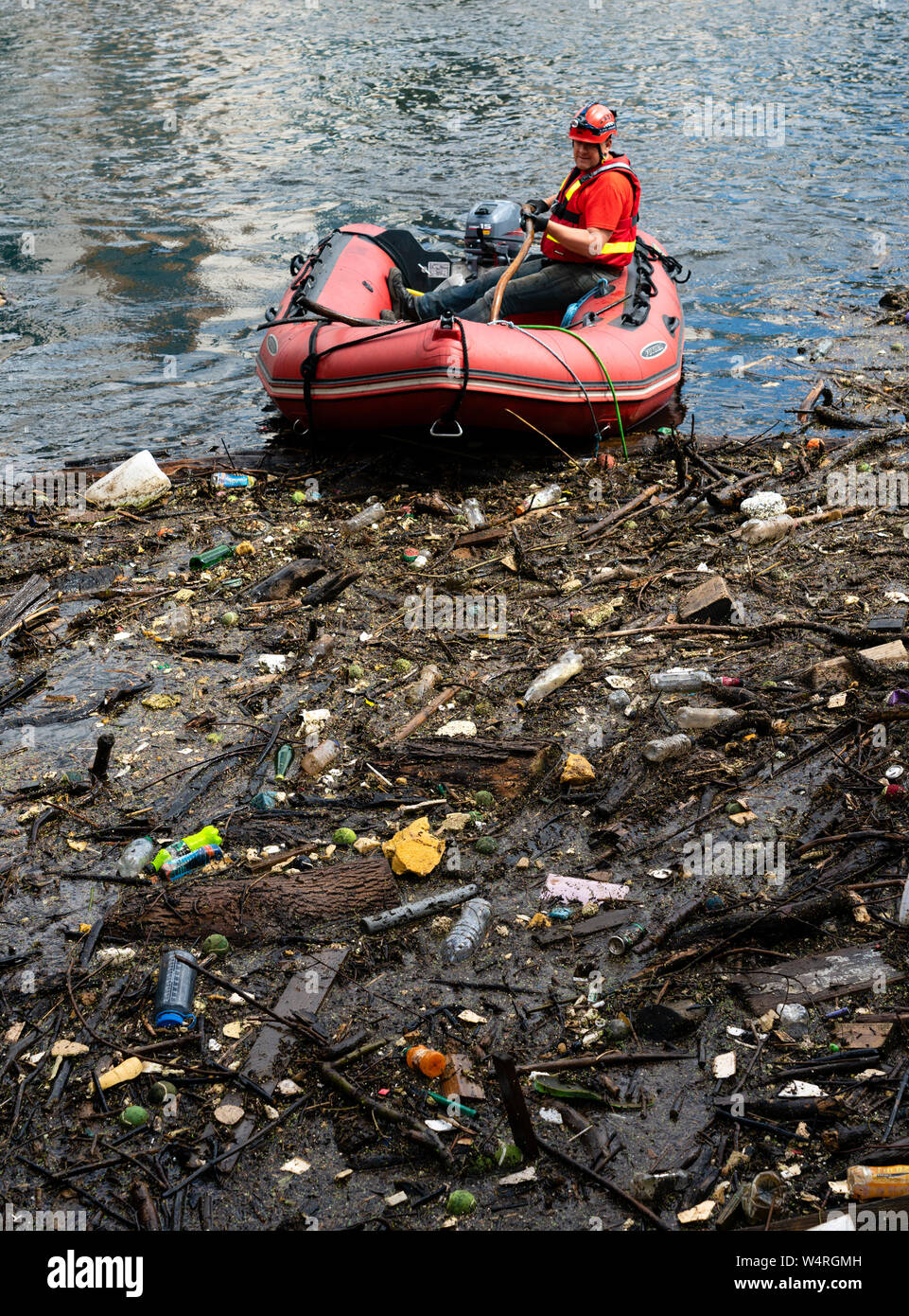 Pulire i detriti raccolti a ponte sulle acque del fiume di Leith a Leith Dopo forti piogge, Scotland, Regno Unito Foto Stock