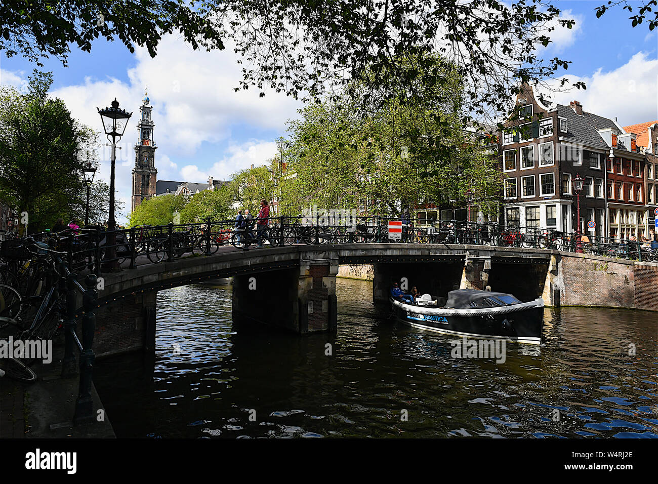 Il motoscafo passando sotto il ponte di arco, Amsterdam, Paesi Bassi Foto Stock