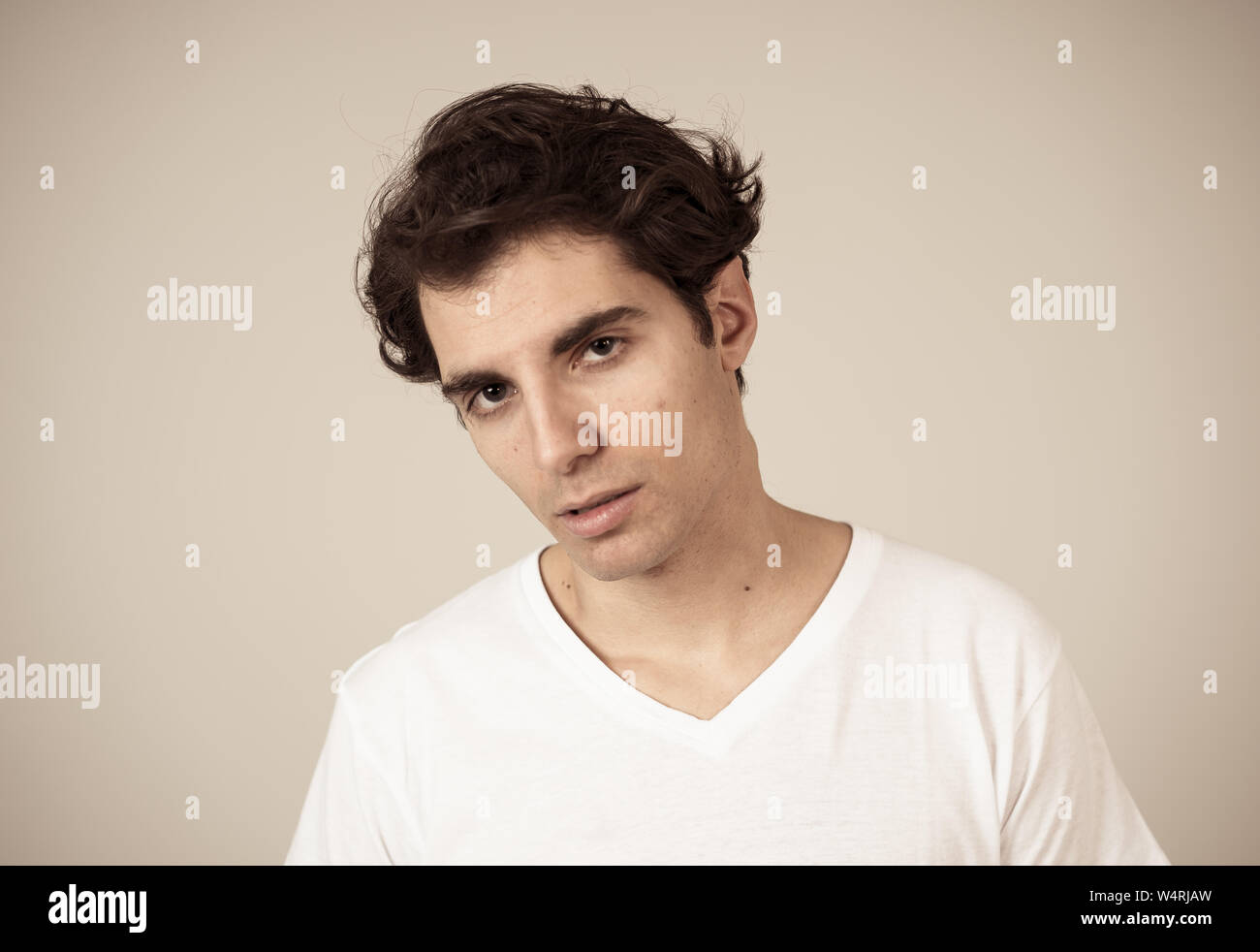 Close up headshot di giovani latino-uomo con naturale e faccia seria e divertente guardare. Isolato su sfondo neutro. In Persone, moda, lifestyle Beaut Foto Stock