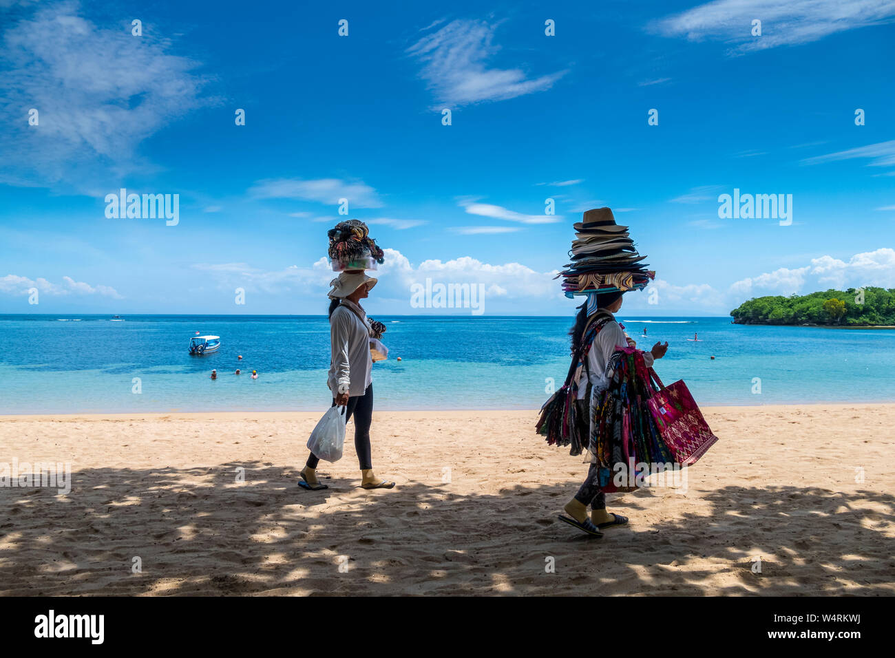 Due donne a piedi lungo la spiaggia di Nusa Dua, Nusa Dua, Bali, Indonesia Foto Stock