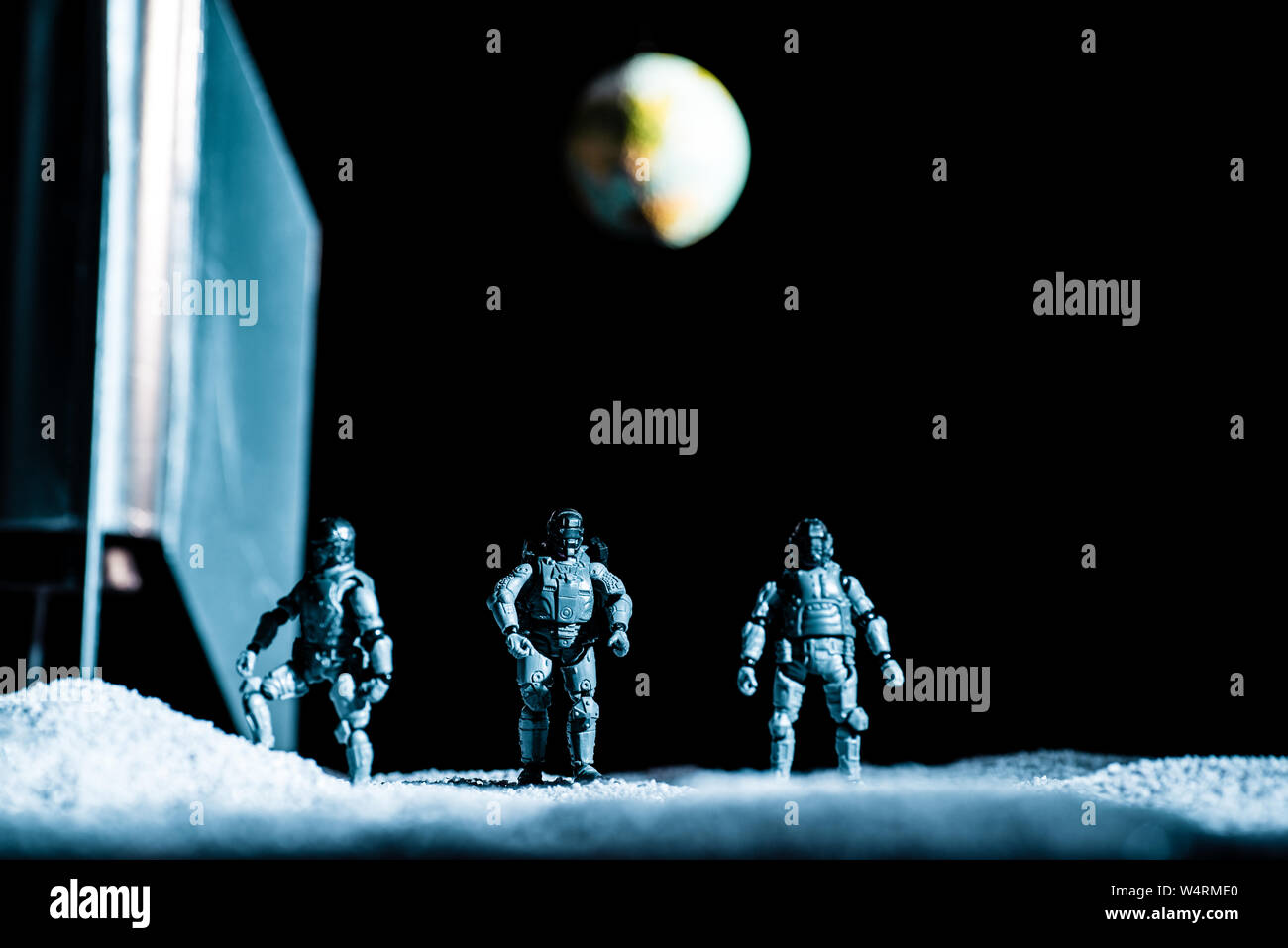 Toy Soldiers in piedi nello spazio su sfondo nero con il pianeta terra Foto Stock