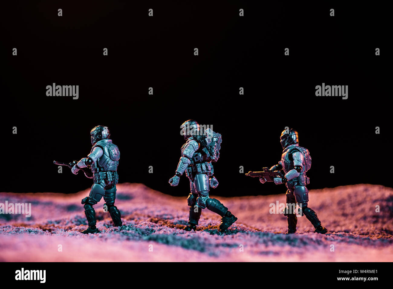 Toy Soldiers camminando con la pistola sul pianeta in spazio isolato su nero Foto Stock