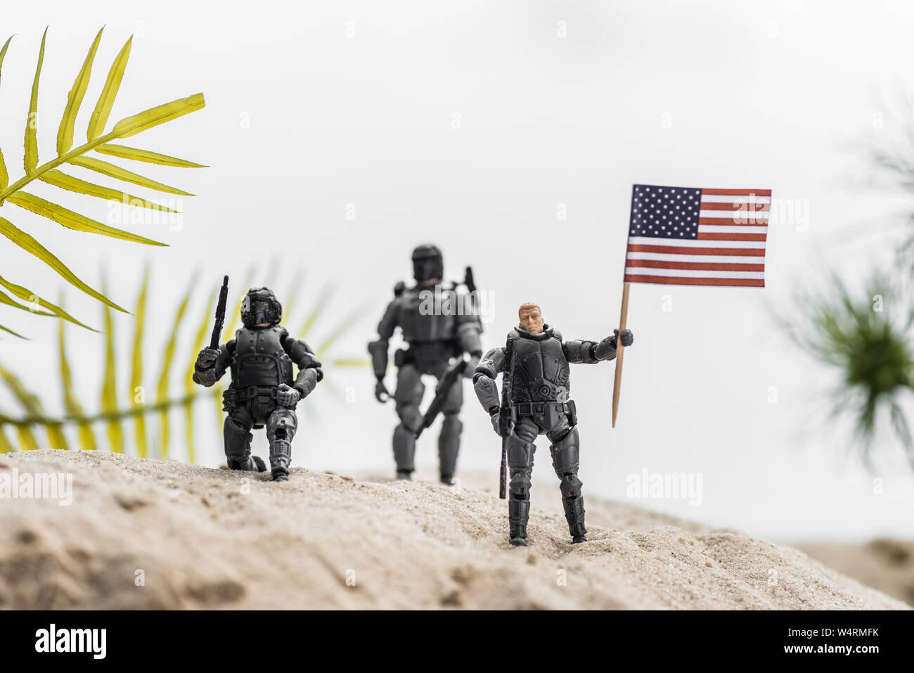 Messa a fuoco selettiva di toy soldiers holding bandiera americana sulla collina di sabbia Foto Stock