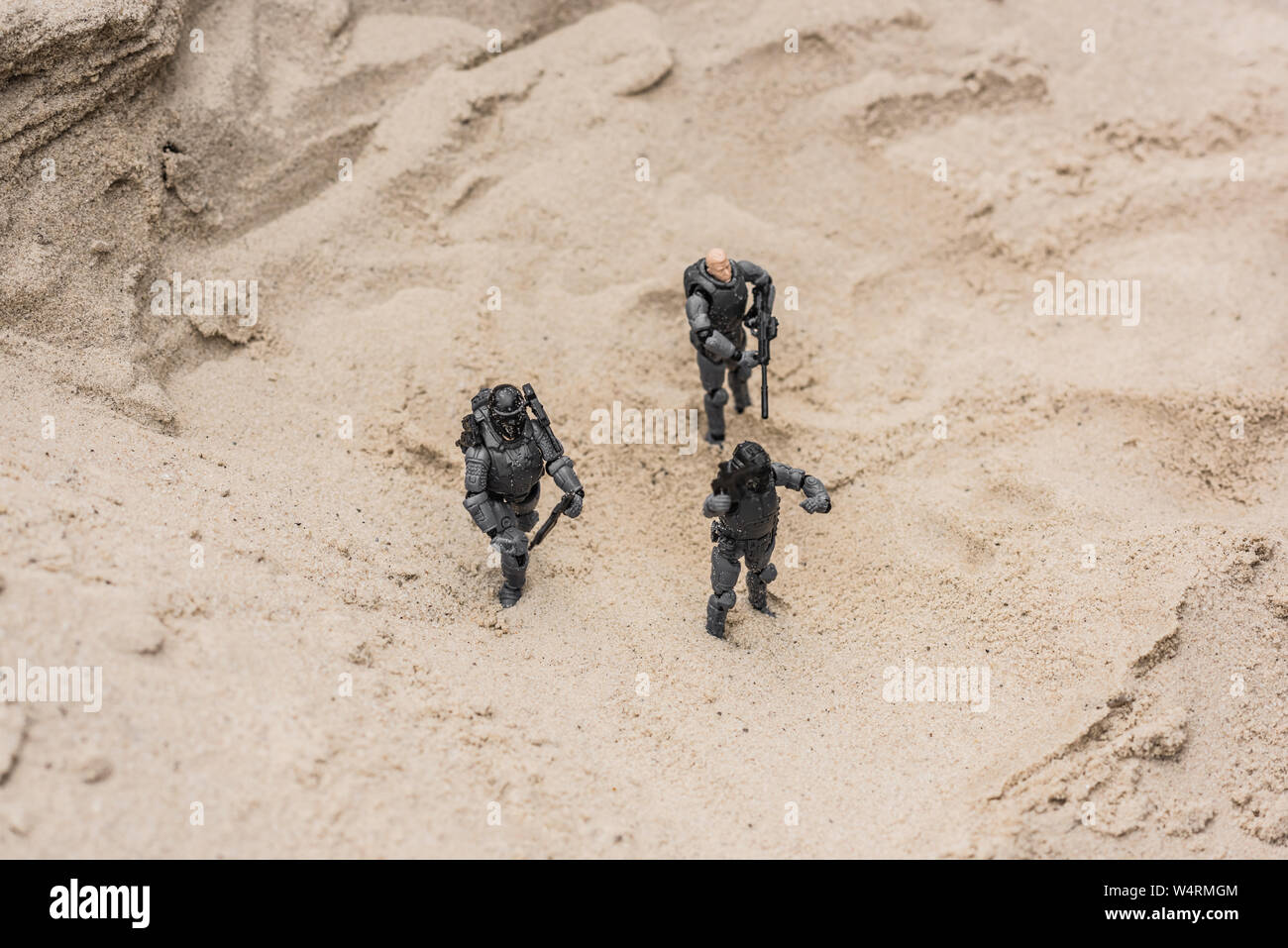 Giocattolo di plastica soldati sulle dune di sabbia con le pistole Foto Stock