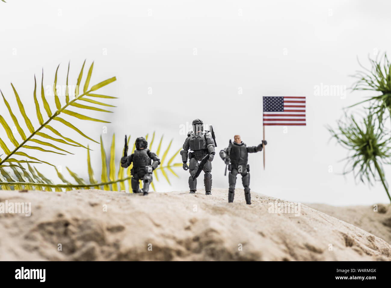 Messa a fuoco selettiva di toy soldiers holding bandiera americana sulla duna di sabbia Foto Stock