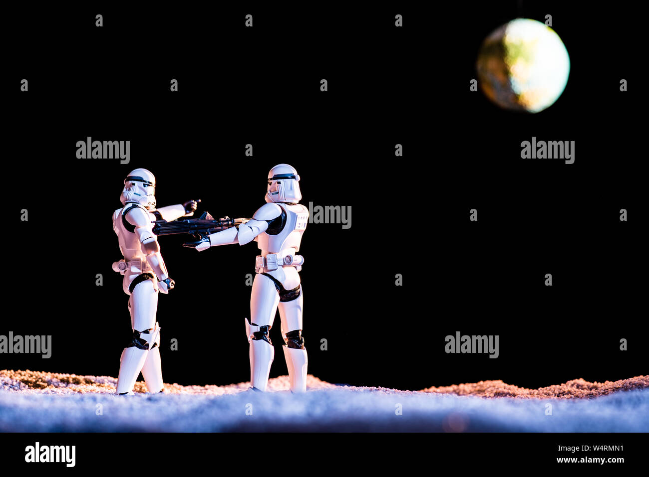 Kiev, Ucraina - 25 Maggio 2019: imperial stormtrooper mirando con arma a un altro su sfondo nero con il pianeta Terra Foto Stock