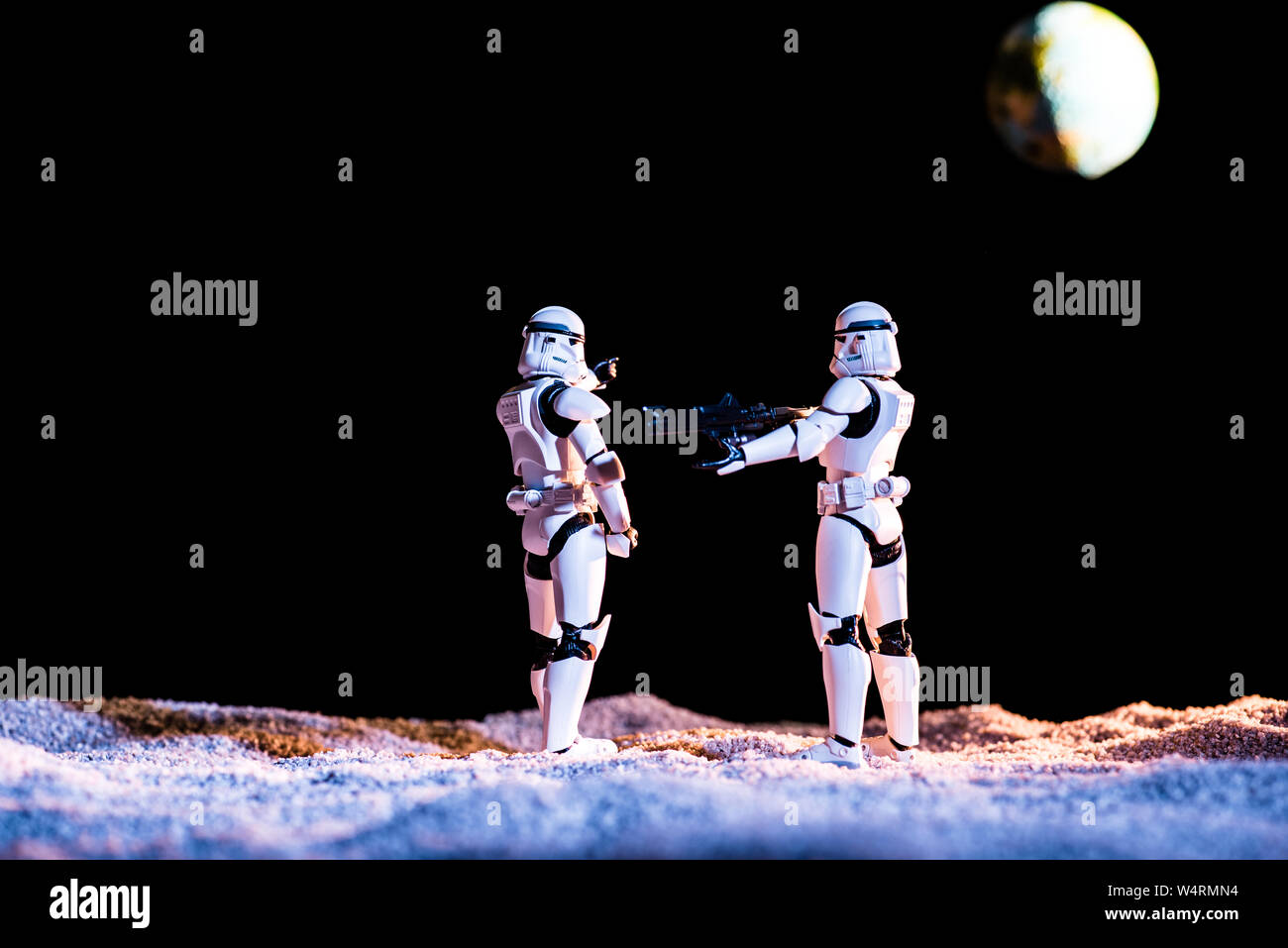 Kiev, Ucraina - 25 Maggio 2019: bianco imperial stormtroopers con pistola su sfondo nero con il pianeta Terra Foto Stock