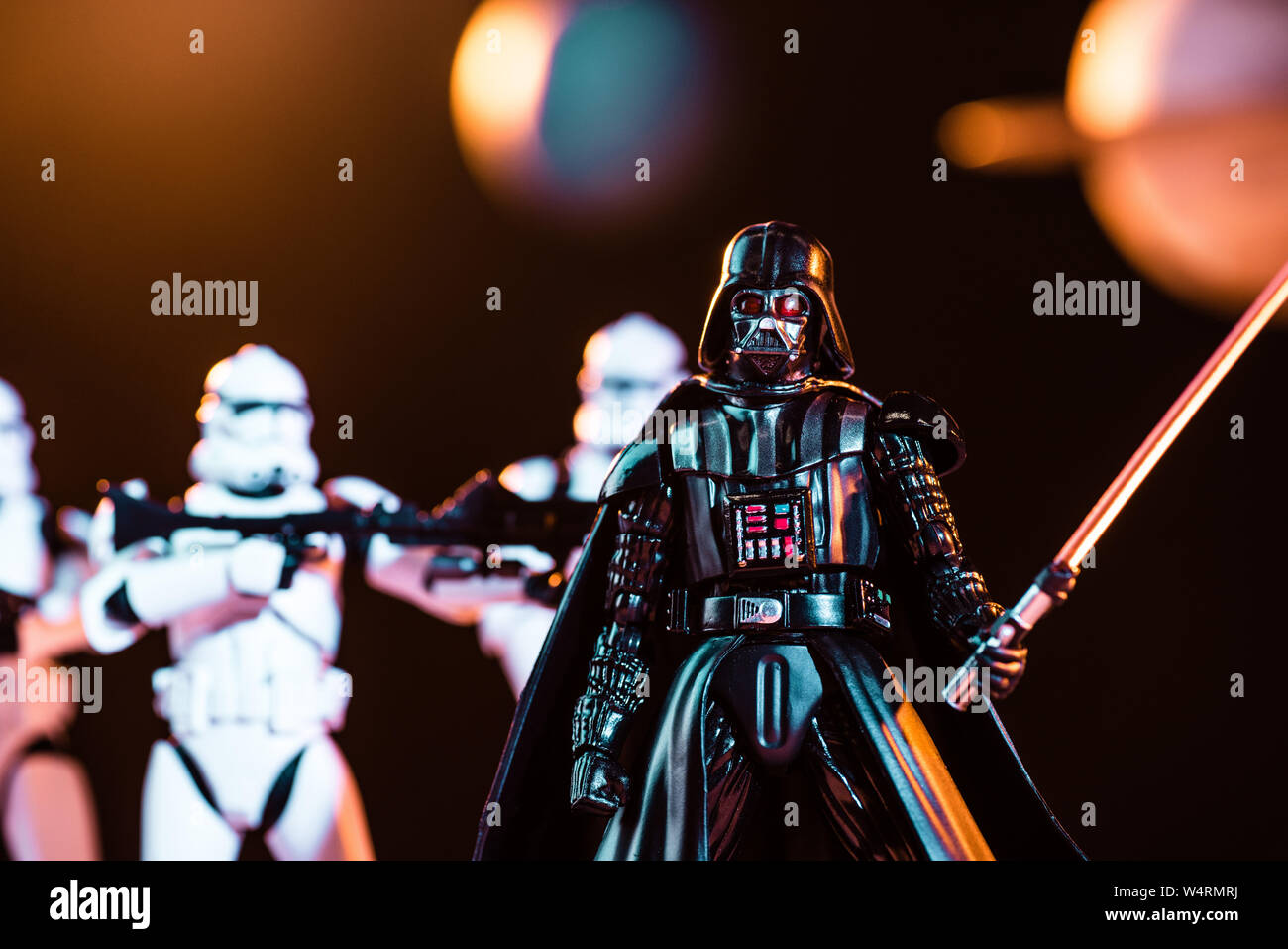 Kiev, Ucraina - 25 Maggio 2019: messa a fuoco selettiva di Darth Vader con spada laser e white imperial stormtroopers con pistole sullo sfondo Foto Stock