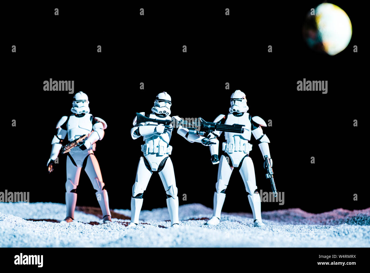 Kiev, Ucraina - 25 Maggio 2019: bianco imperial stormtroopers con pistole su sfondo nero con il pianeta Terra Foto Stock