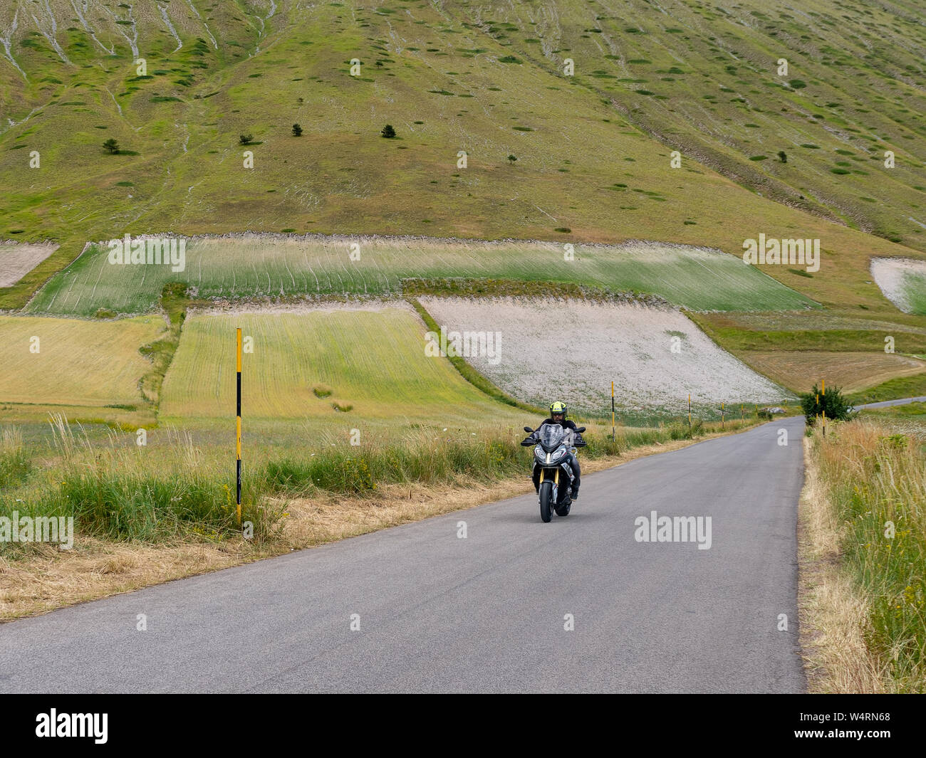 CASTELLUCCIO DI NORCIA, Italia - 14 luglio 2019: Unidentified motociclista sulla strada aperta, Castelluccio di Norcia, Italia. Foto Stock