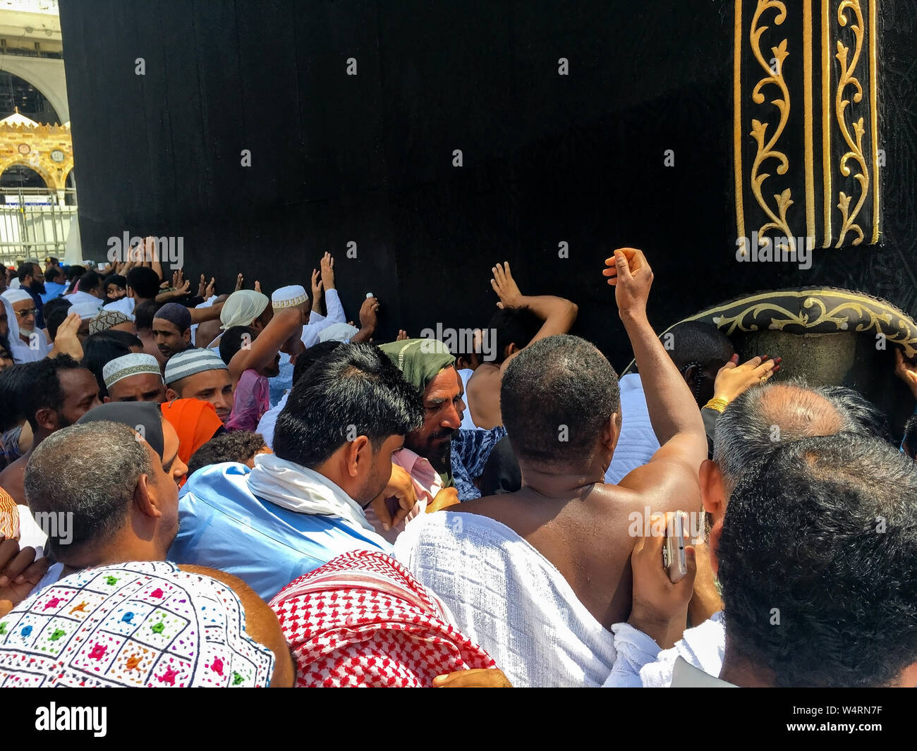 La Mecca, Arabia Saudita - 28 giugno: Unidentified musulmani pellegrini in bianco ihram touch panno nero di Kaaba con Allah e Muhammad (pace sia su di lui) insc Foto Stock