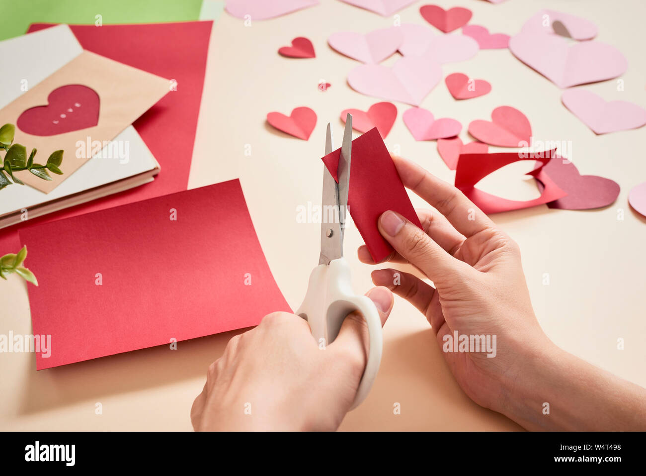 Donna taglia fuori feltro rosso cuori, artigianato fatti in casa per il giorno di San Valentino, fatto a mano la creatività, la vista superiore Foto Stock