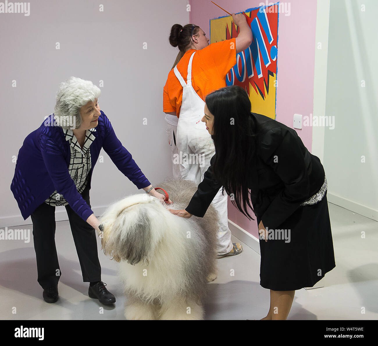 Priti Patel MP apre la Dulux Academy, Akzo Nobel, Slough. Il 17 marzo 2016. Ministro di Stato per l'occupazione Priti Patel si è formalmente aperto il Dulux Academy presso la Akzo Nobel sito in Slough. Qui si incontra con la Dulux cane. La Dulux Academy insegna pittori e decoratori pittura delle competenze e abilità di spruzzatura nella decorazione di industria. Credito: Maureen McLean/Alamy Foto Stock