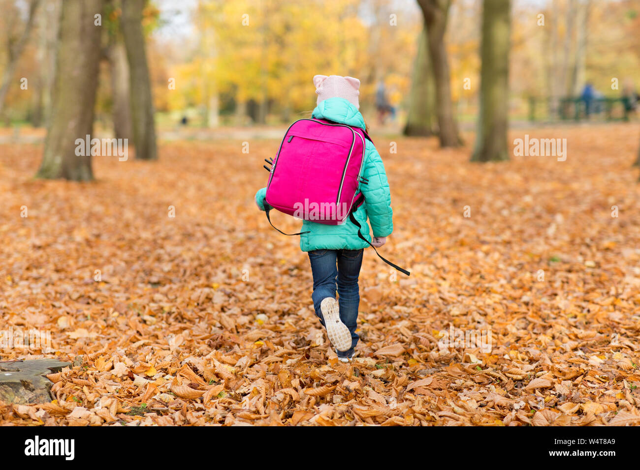 Bambina con la scuola in borsa in autunno park Foto Stock