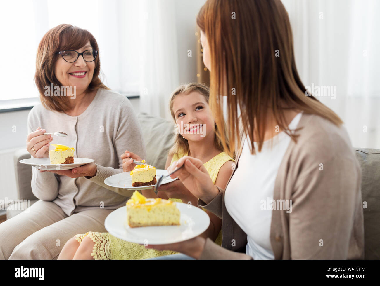 Figlia della madre e nonna di mangiare la torta Foto Stock