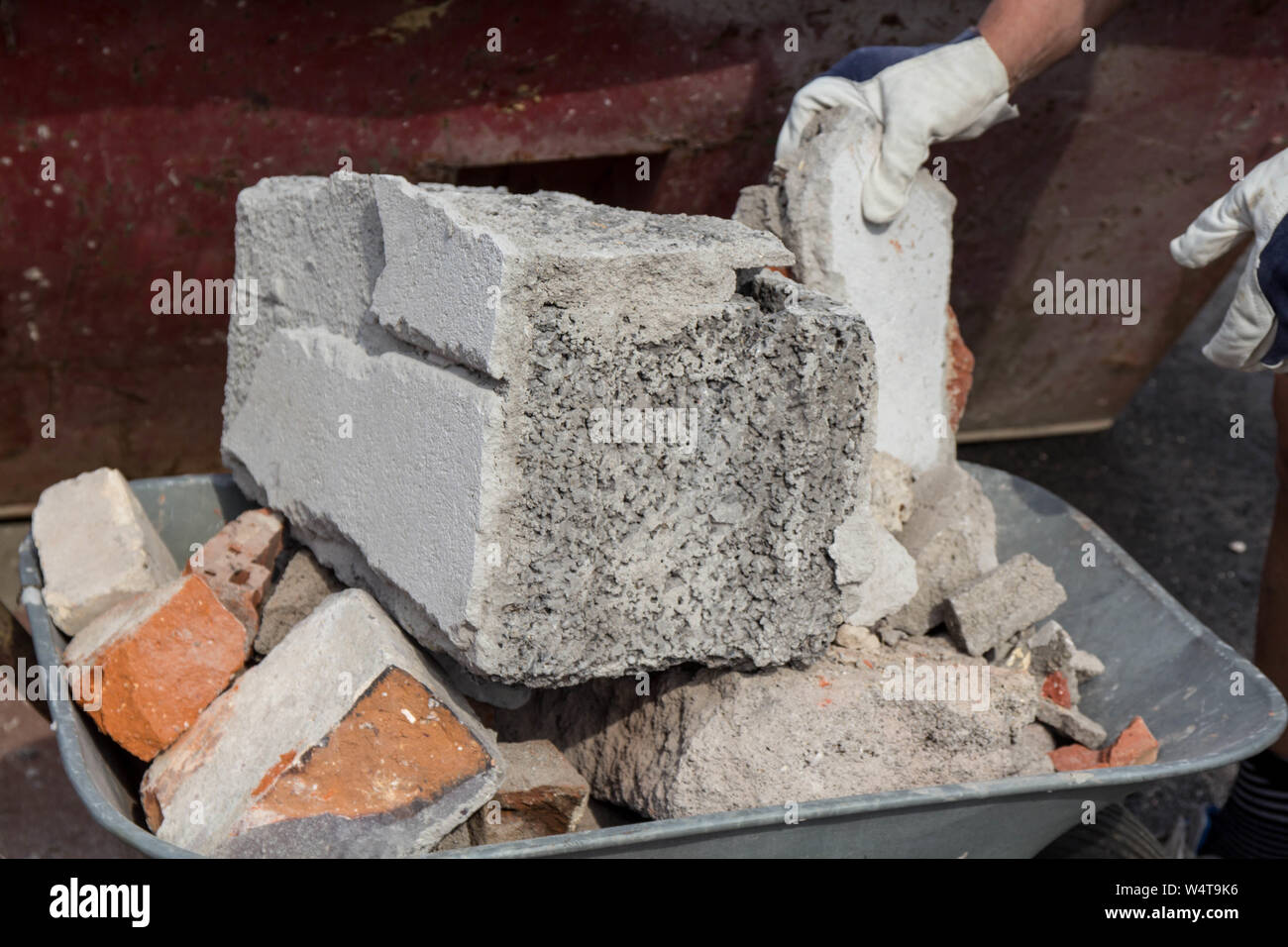 Immissione detriti di costruzione su una carriola Foto Stock