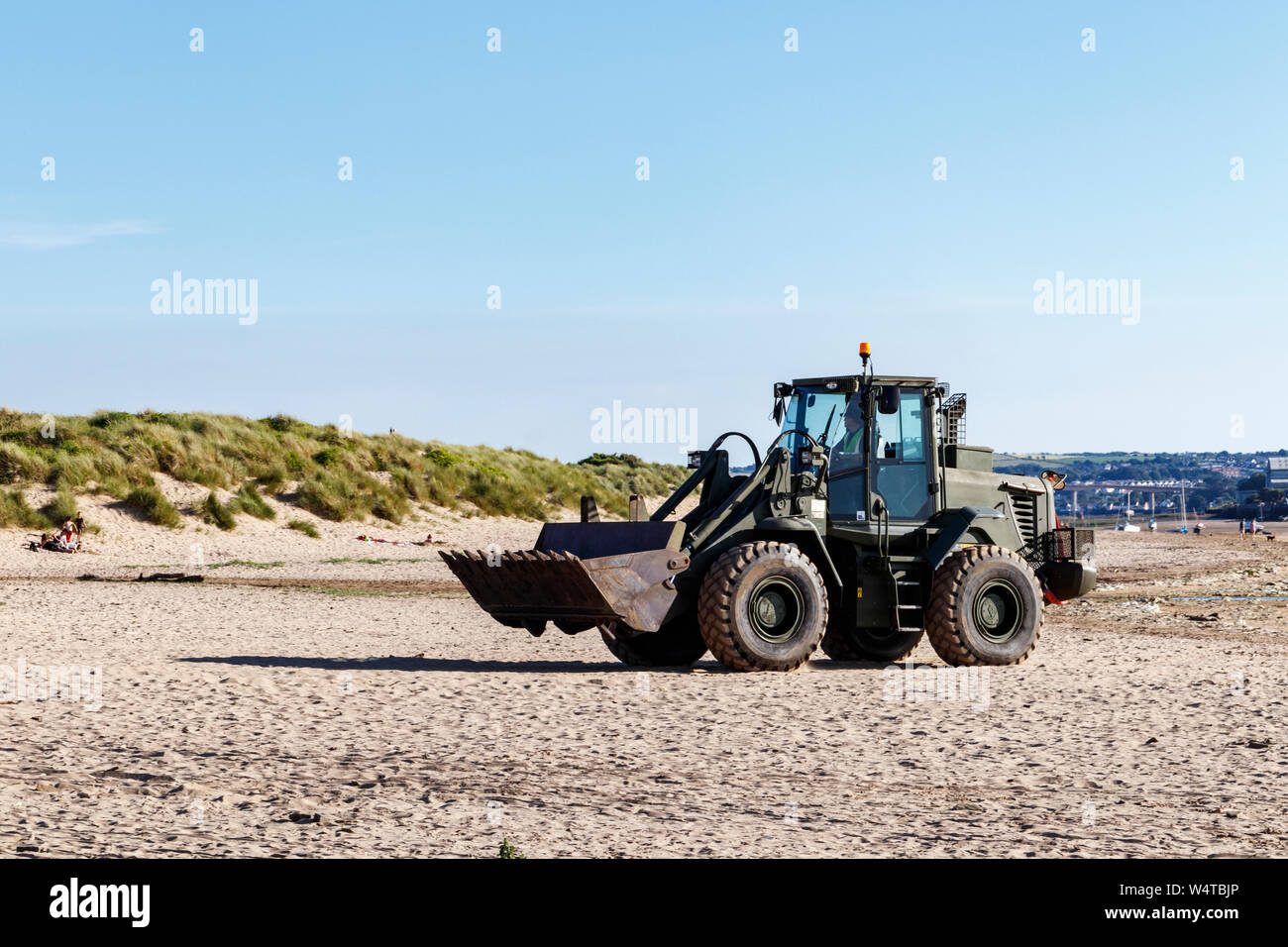 Un escavatore JCB sulla spiaggia sabbiosa a Instow, Devon, Regno Unito Foto Stock