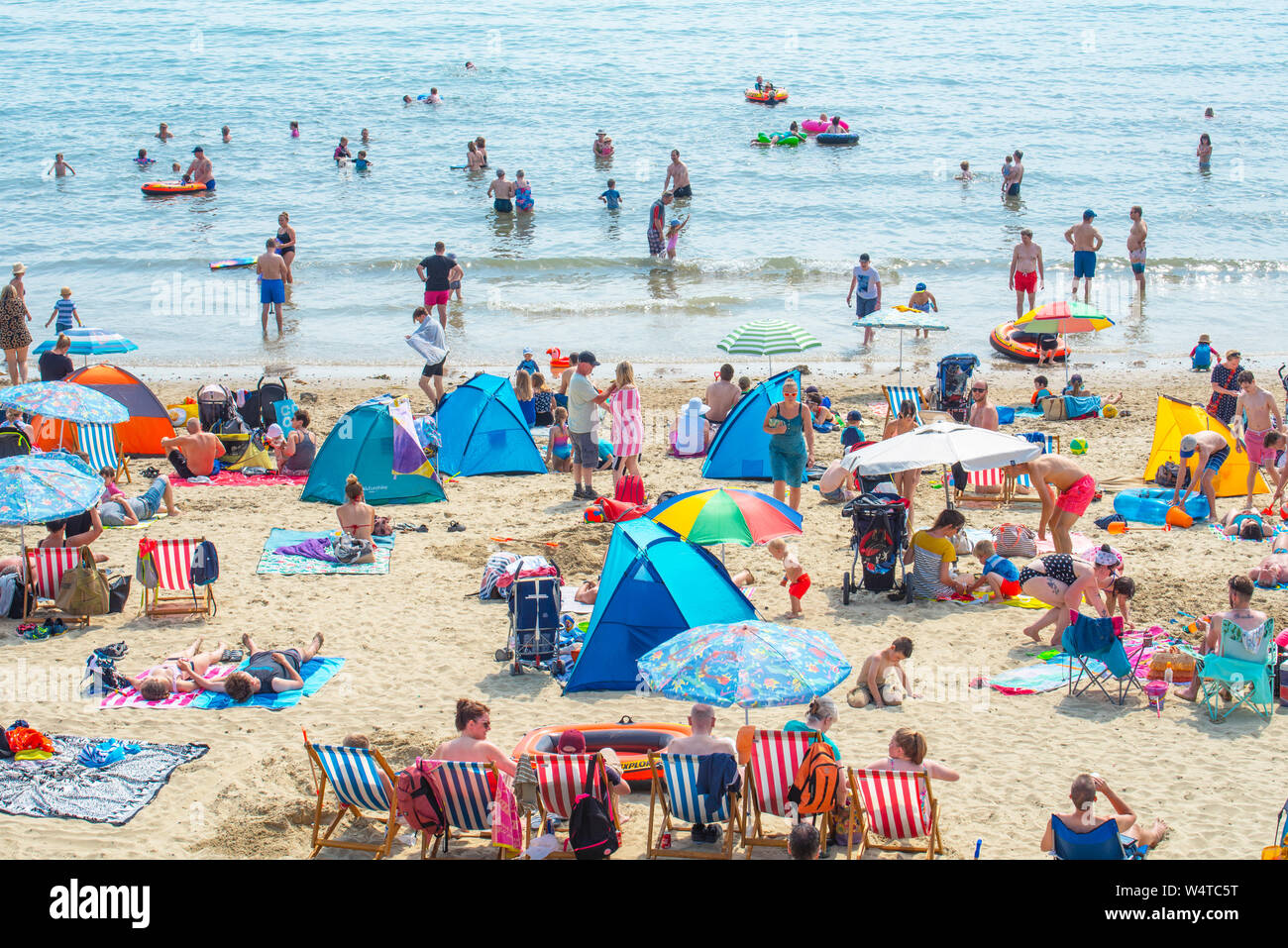Lyme Regis, Dorset, Regno Unito. Il 25 luglio 2019. Meteo REGNO UNITO: folle di sunskeekers swelter a battere i record di calore sulla spiaggia presso la località balneare di Lyme Regis su quello che dovrebbe essere il giorno più caldo nel Regno Unito mai. I vacanzieri inglesi swelter in sfrigolanti sole caldissimo sulla città del pranzo spiaggia come le temperature si elevano verso 40 gradi centigradi. Il mare di raffreddamento è sollievo dal caldo torrido come la canicola di luglio continua. Credito: Celia McMahon/Alamy Live News. Foto Stock