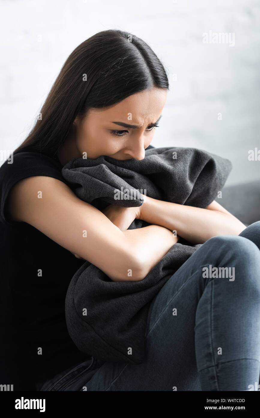 Disperato donna giovane costeggiata dal cuscino mentre affetti da depressione a casa Foto Stock