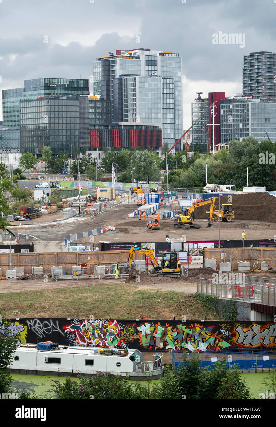 Oriente stoppino e sviluppo Sweetwater cantiere nel Queen Elizabeth Olympic Park, East London, Regno Unito, con il Quartiere Internazionale dietro. Foto Stock