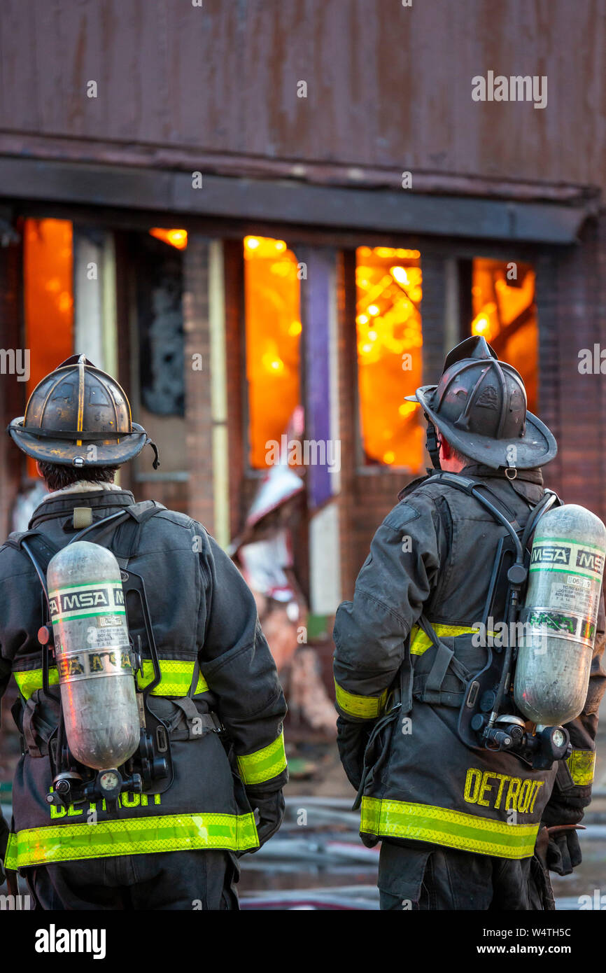 Detroit, Michigan - Vigili del Fuoco attendere prima di entrare in un ardente, a lungo vacanti in centro di struttura. La costruzione di una volta alloggiata l'oro dollaro, un club whic Foto Stock