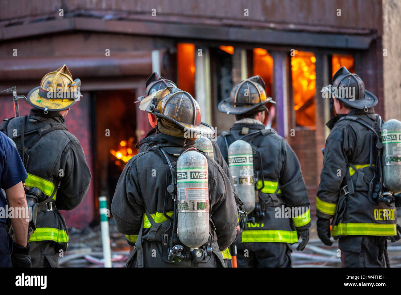 Detroit, Michigan - Vigili del Fuoco attendere prima di entrare in un ardente, a lungo vacanti in centro di struttura. La costruzione di una volta alloggiata l'oro dollaro, un club whic Foto Stock