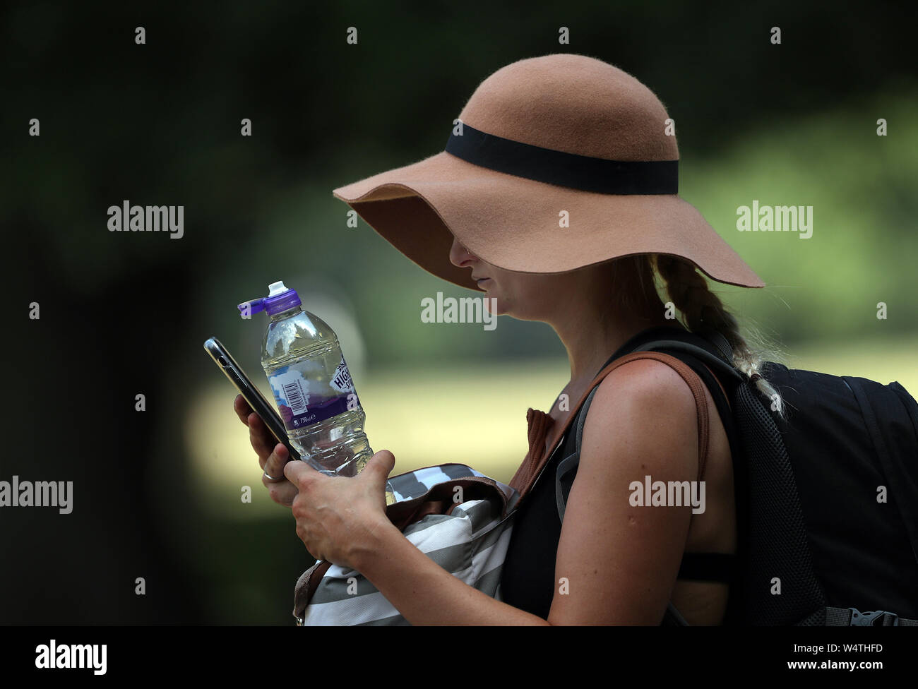 Una giovane donna cerca di conservare al fresco in Hyde Park, Londra, dopo che le temperature sono saliti al di sopra di 30C in alcune parti del Regno Unito dopo una notte tropicale, come paese bretelle per record di calore. Foto Stock