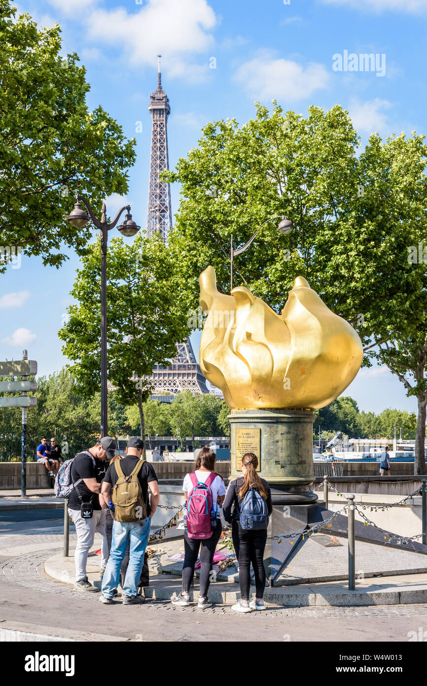 I turisti in piedi di fronte alla fiamma della libertà di Parigi, Francia, che divenne un memoriale per la Principessa Diana che morì nel tunnel sotto. Foto Stock