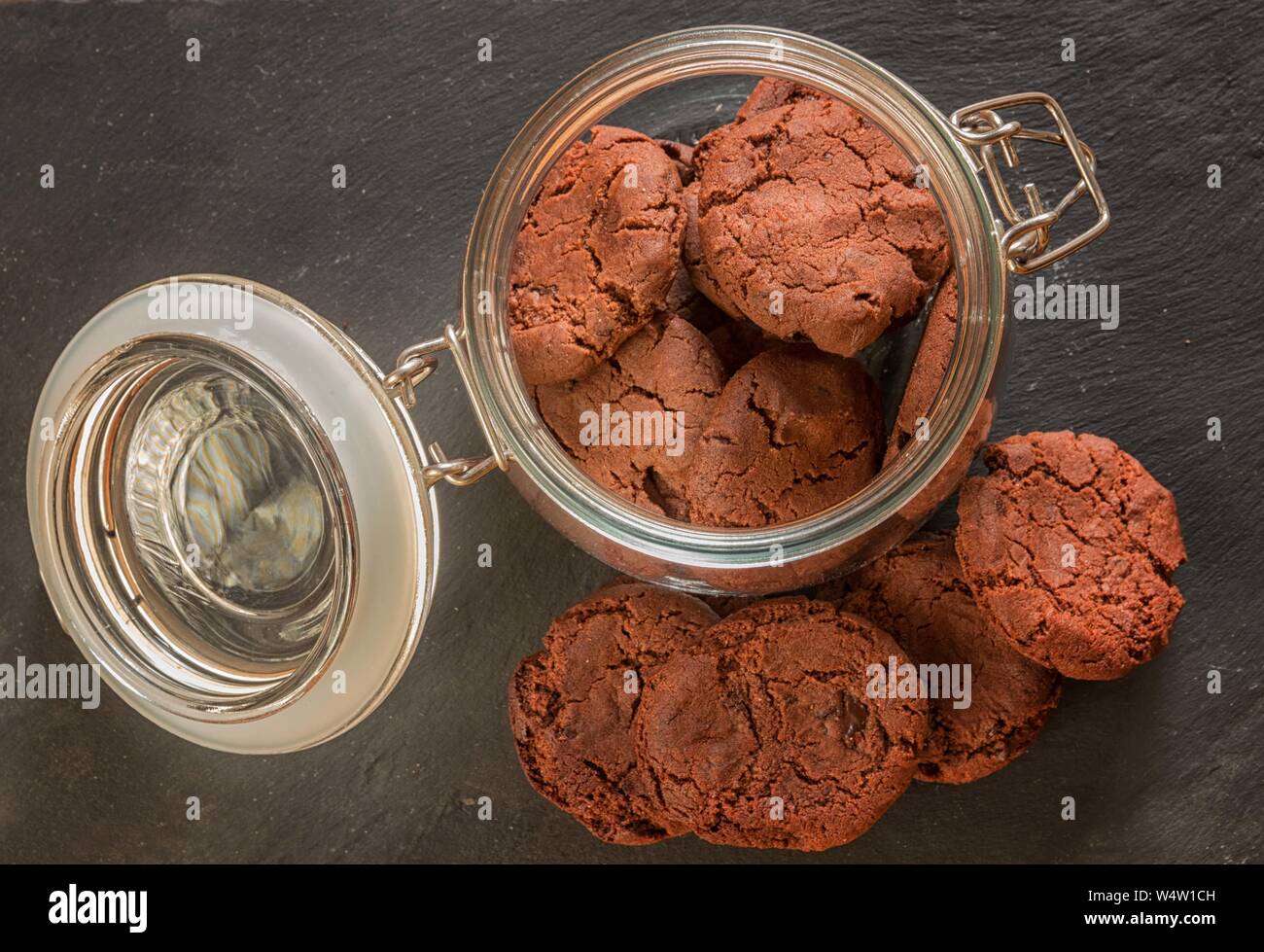 Guardando verso il basso sui cookies un cookie di vetro barattolo in piedi su un sfondo di ardesia Foto Stock