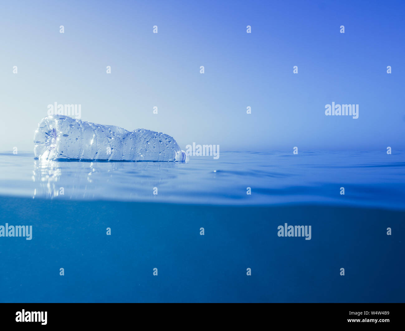 Rifiuti di plastica all'oceano, una bottiglia di plastica galleggiante nel mare Mediterraneo in corrispondenza della superficie dell'acqua, problema ambientale con le materie plastiche inquinamento, co Foto Stock