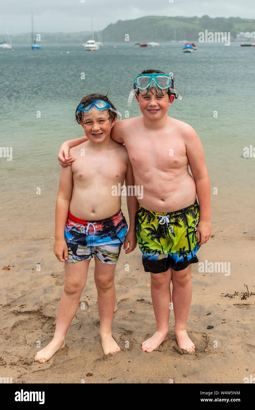 Bantry, West Cork, Irlanda. Xxv Luglio, 2019. Pur in assenza di una ondata di caldo in Irlanda, questi ragazzi locali, Donnacha e Lucas Cronin-Murphy da Bantry non furono messi fuori da giocare presso la spiaggia di il vento e la pioggia. La pioggia continuerà in serata con le temperature massime di 20 a 25°C. Credito: Andy Gibson/Alamy Live News. Foto Stock