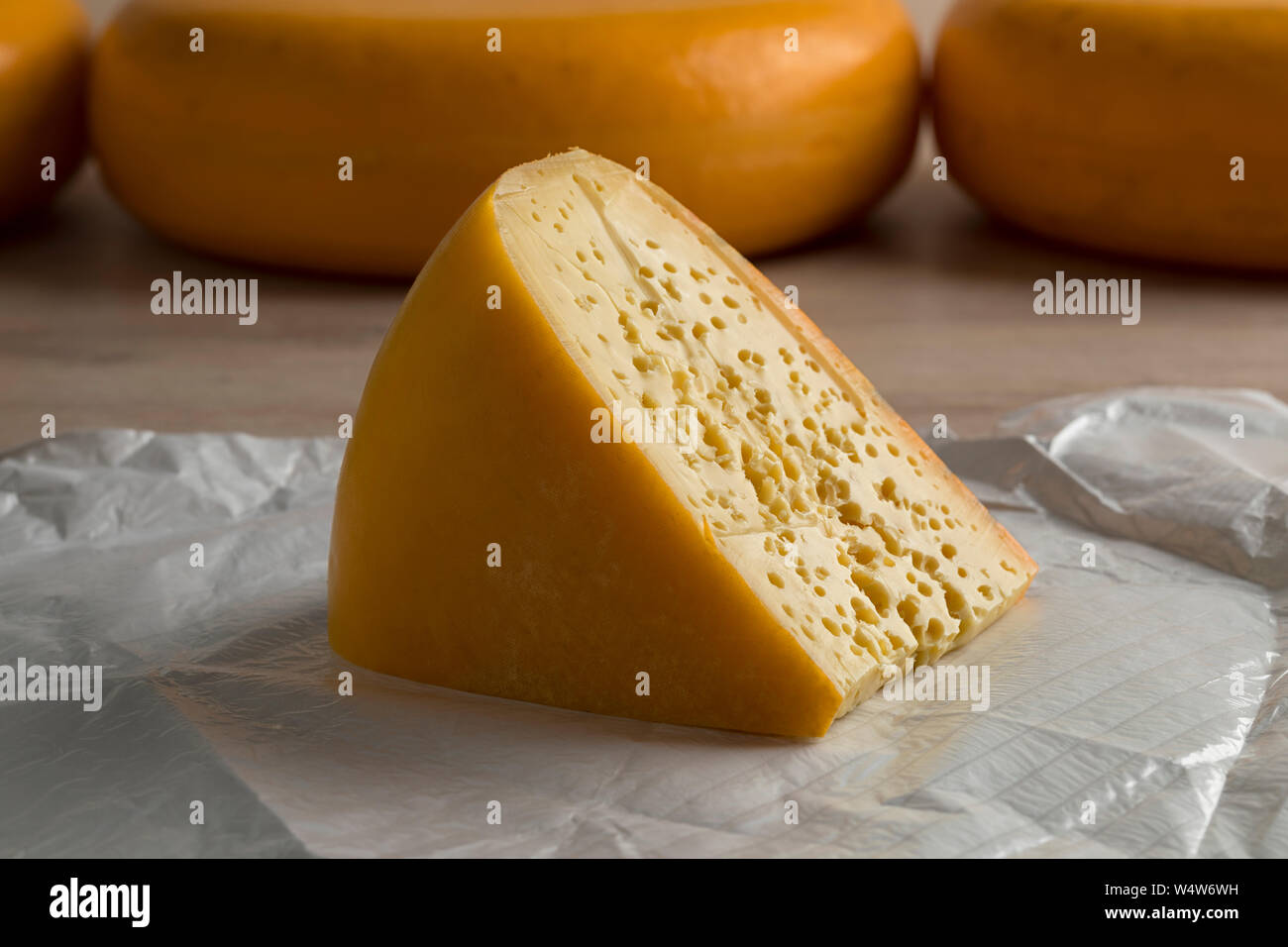 Pezzo di Stolwijker olandese formaggio con i fori sulla carta Foto Stock