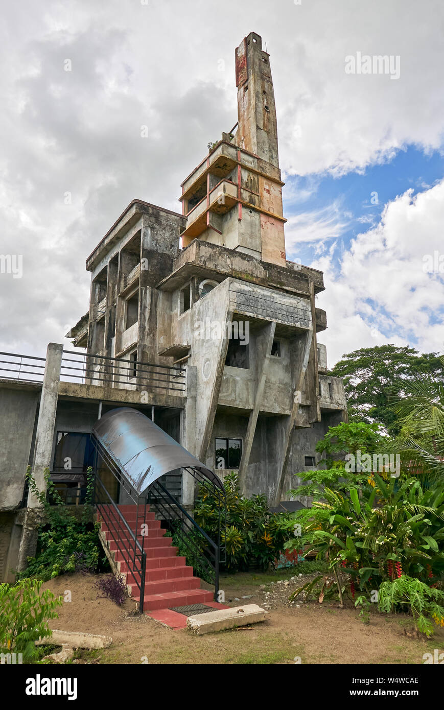 A basso angolo di visione di uno strano incompiuta bizzarro edificio in cemento della città Cuartero nelle Filippine. Persone che vivono solo nel piano inferiore. Foto Stock