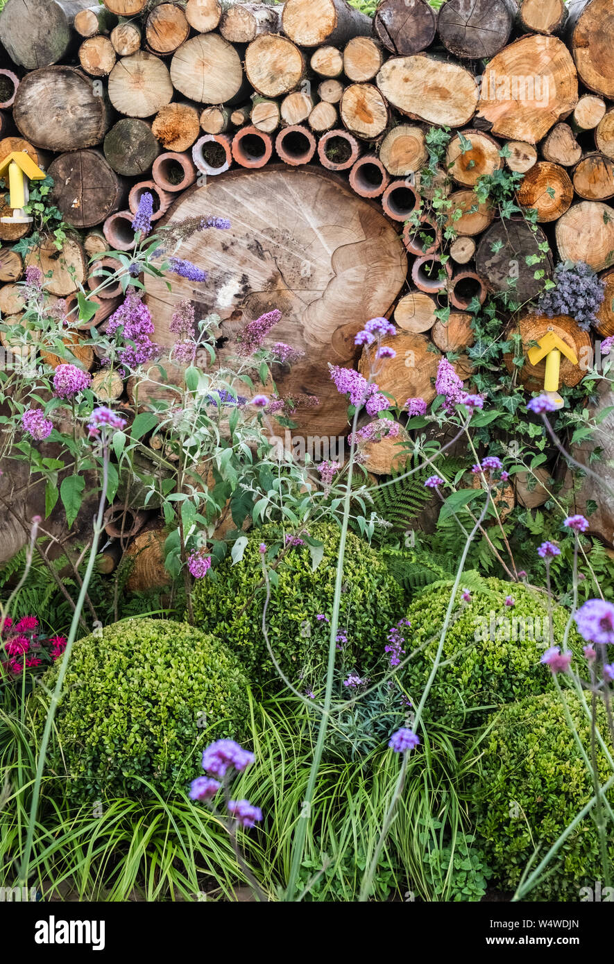 Visualizza Giardino a Tatton Park Flower Show, 2019, incorporante wildlife friendly funzioni come tronchi di legno e canne di bambù per insetti, Cheshire, Regno Unito Foto Stock