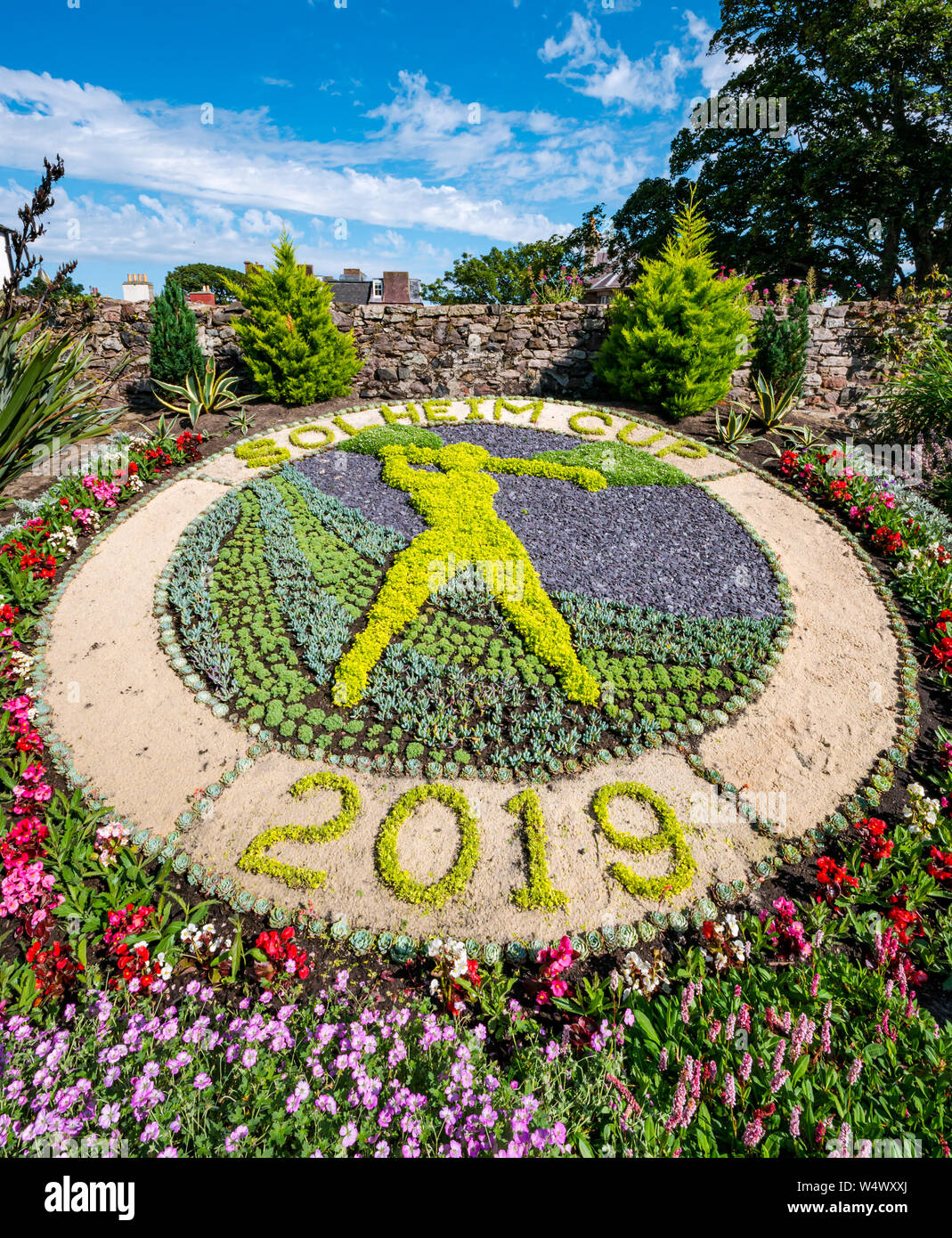 Solheim Cup con raffigurazione di professional golfer swinging golf club nel letto di fiori, Lodge motivi giardino, North Berwick, East Lothian, Scozia, Regno Unito Foto Stock