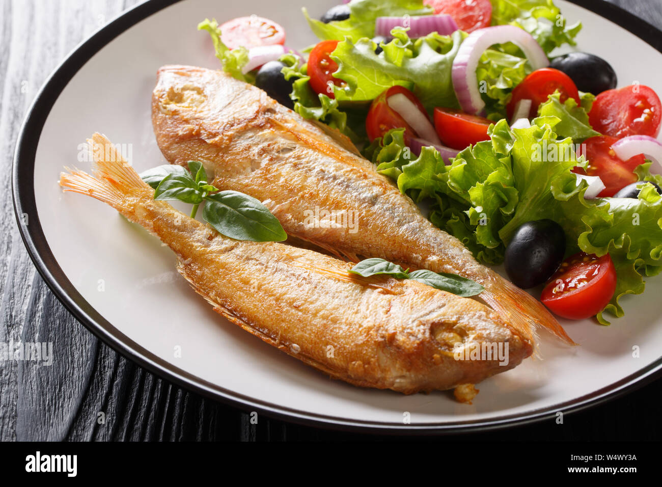 Cucinata fresca rosa dorado pesce con limone e insalata di verdure close-up su una piastra sul tavolo orizzontale. Foto Stock