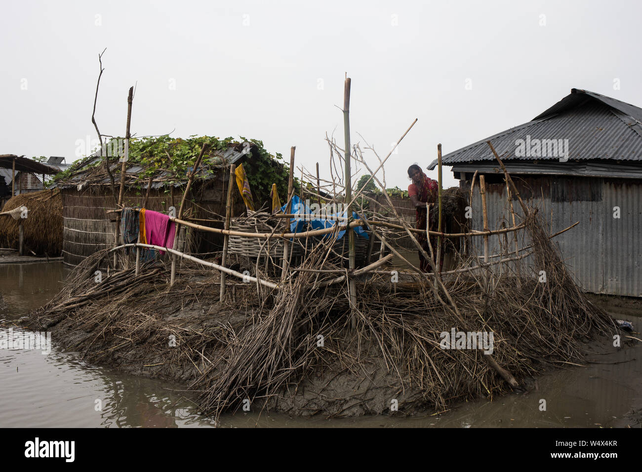 Una donna che lavorano dentro casa sua dopo il livello di acqua è andato giù. Foto Stock