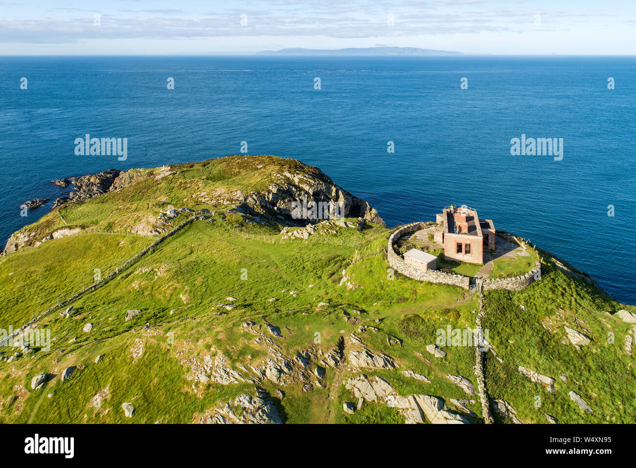 Torr capo operazioni automatiche di fine campo, scogliera rocciosa penisola e con le rovine della vecchia fortezza nella contea di Antrim, Irlanda del Nord, vicino a Ballycastle. Foto aerea con il punto di vista lontano Foto Stock