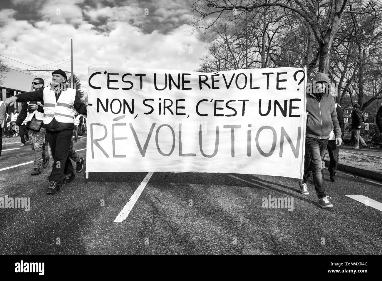 Strasburgo, Francia - Feb 02, 2018: persone marciando durante la protesta di Gilets Jaunes Giubbotto giallo manifestazione manifestazioni antigovernative con questa è una rivoluzione sulla targhetta Foto Stock