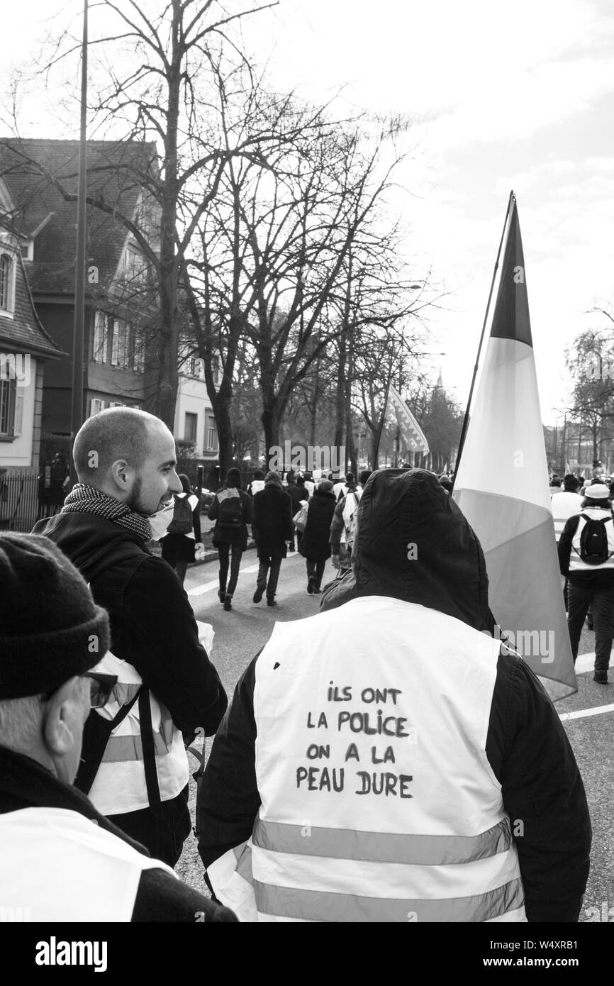 Strasburgo, Francia - Feb 02, 2018: persone marciando durante la protesta di Gilets Jaunes manifestazione manifestazioni antigovernative abbiamo la pelle dura iscrizione sul giubbotto di colore giallo Foto Stock