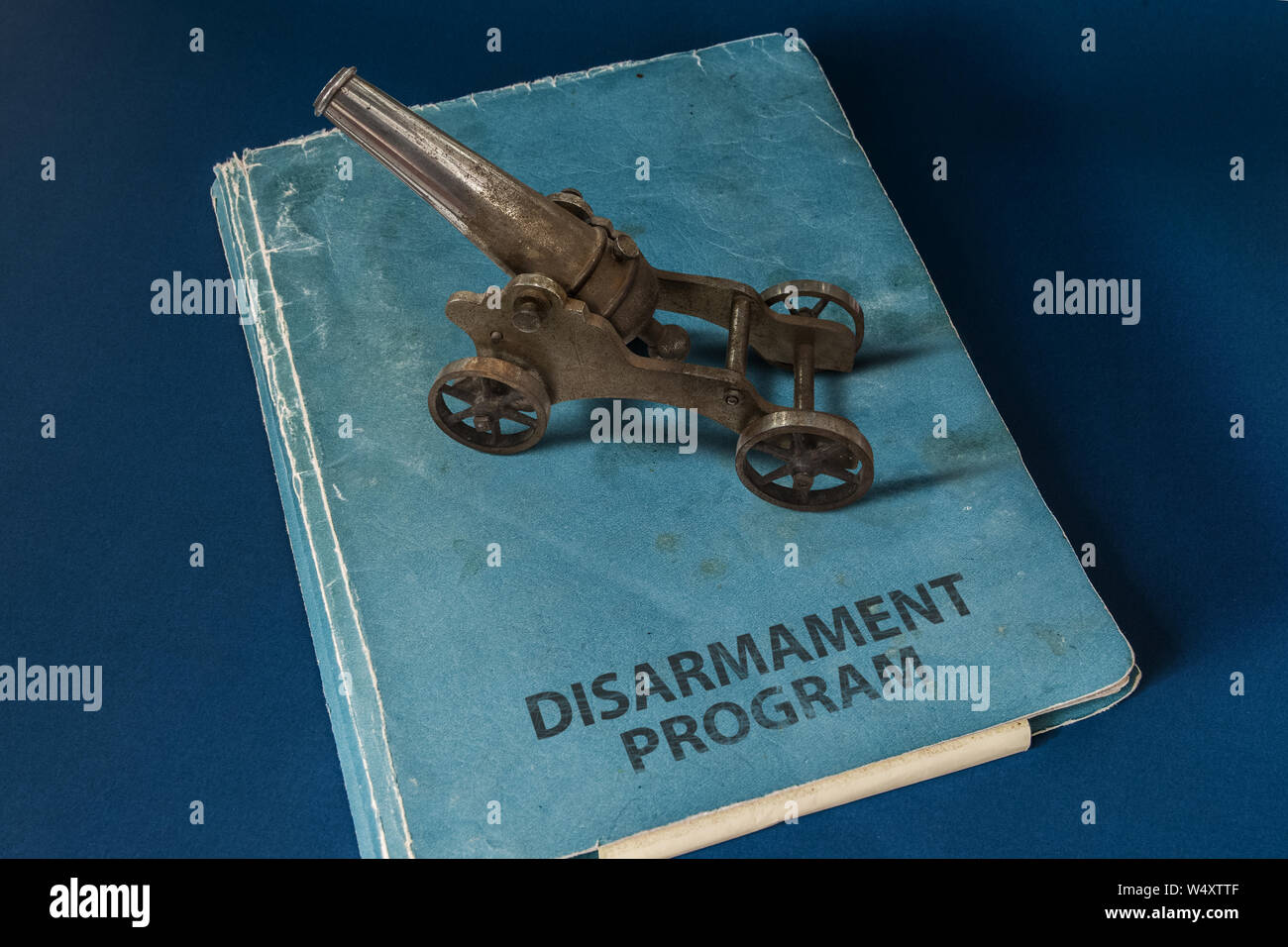 Un piccolo polvere nera cannone sulla parte superiore di un documento il cui titolo è: programma di disarmo. Foto Stock