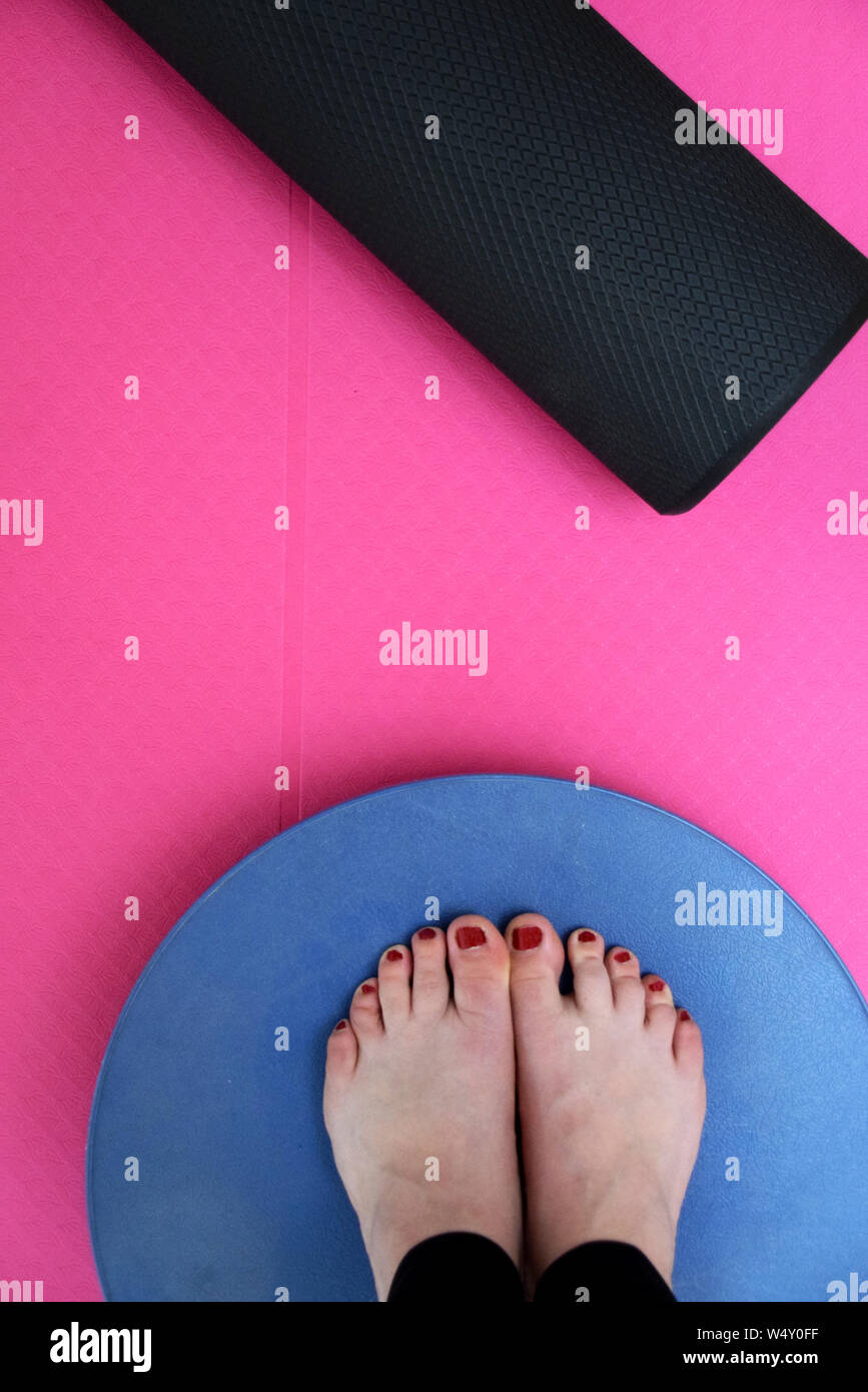 Esercizio con materassino yoga e il rullo in gomma spugna e piedi permanente sulla balance board Foto Stock