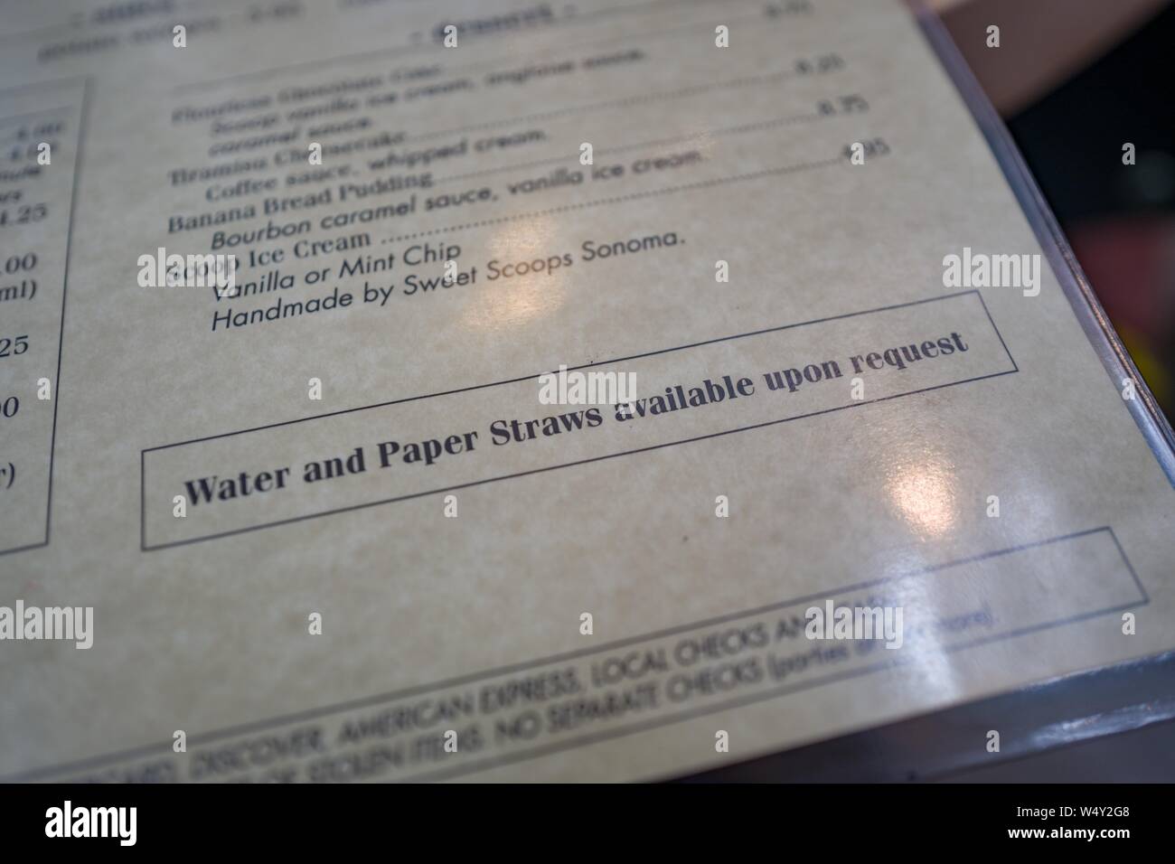 Close-up del ristorante con menu testo di lettura acqua e Cannucce disponibili su richiesta e con riferimento ai regolamenti nella Bay Area di San Francisco ristoranti che vieta di fornire questi elementi a tutti gli ospiti come parte delle misure di protezione ambientale, nella contea di Sonoma, Sonoma, California, 12 aprile 2019. () Foto Stock