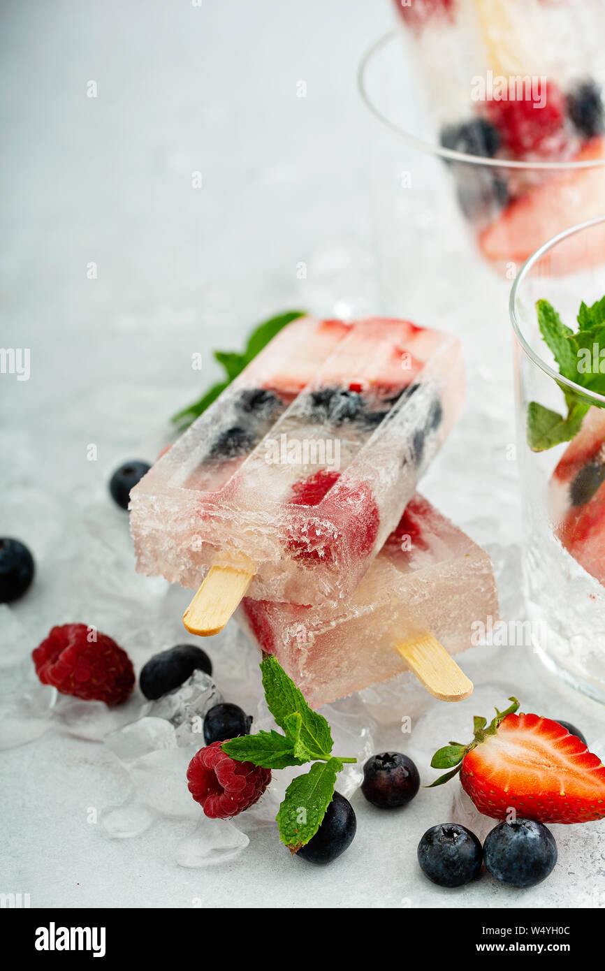 Popsicles champagne con fragole, lamponi e mirtilli Foto Stock