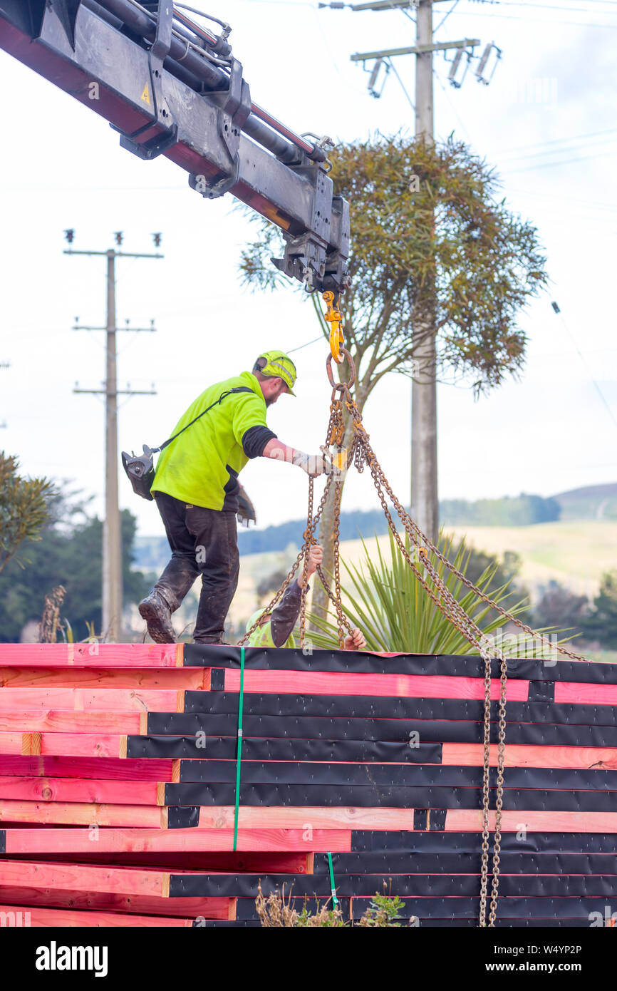 Sheffield. Canterbury, Nuova Zelanda, 25 Luglio 2019: costruttori scaricare capriate che sono stati consegnati da un carrello Hiab ad un sito di costruzione Foto Stock