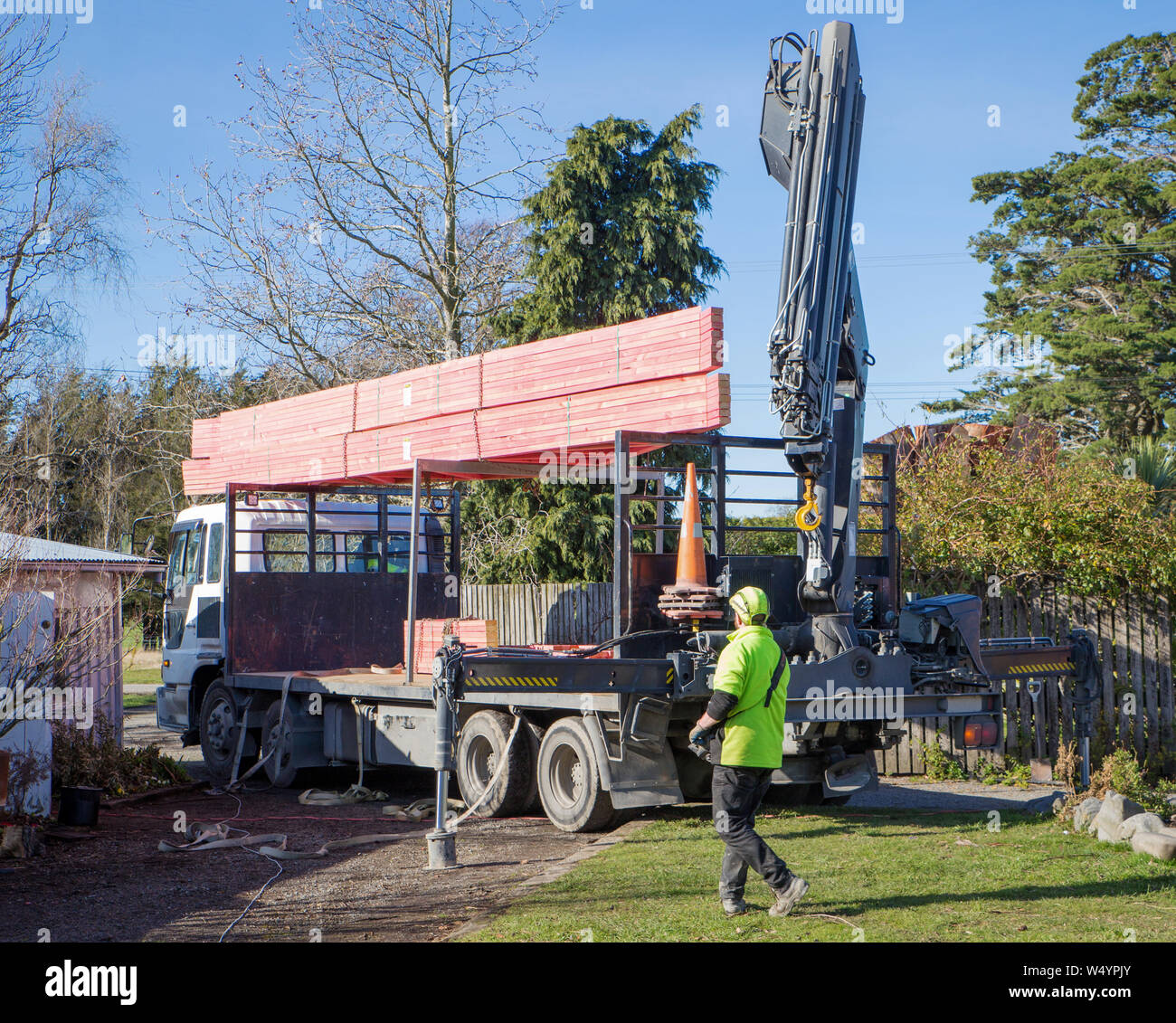 Sheffield. Canterbury, Nuova Zelanda, 25 Luglio 2019: costruttori scaricare capriate che sono stati consegnati da un carrello Hiab ad un sito di costruzione Foto Stock