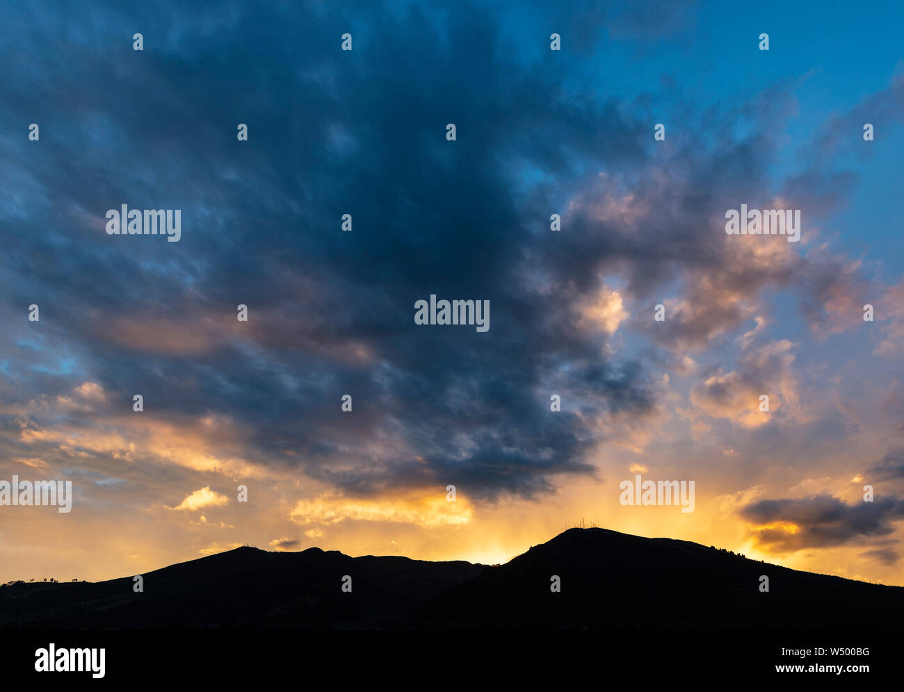 Silhouette della potente vulcano Pichincha al tramonto con sunbeam, città di Quito, Ecuador. Foto Stock