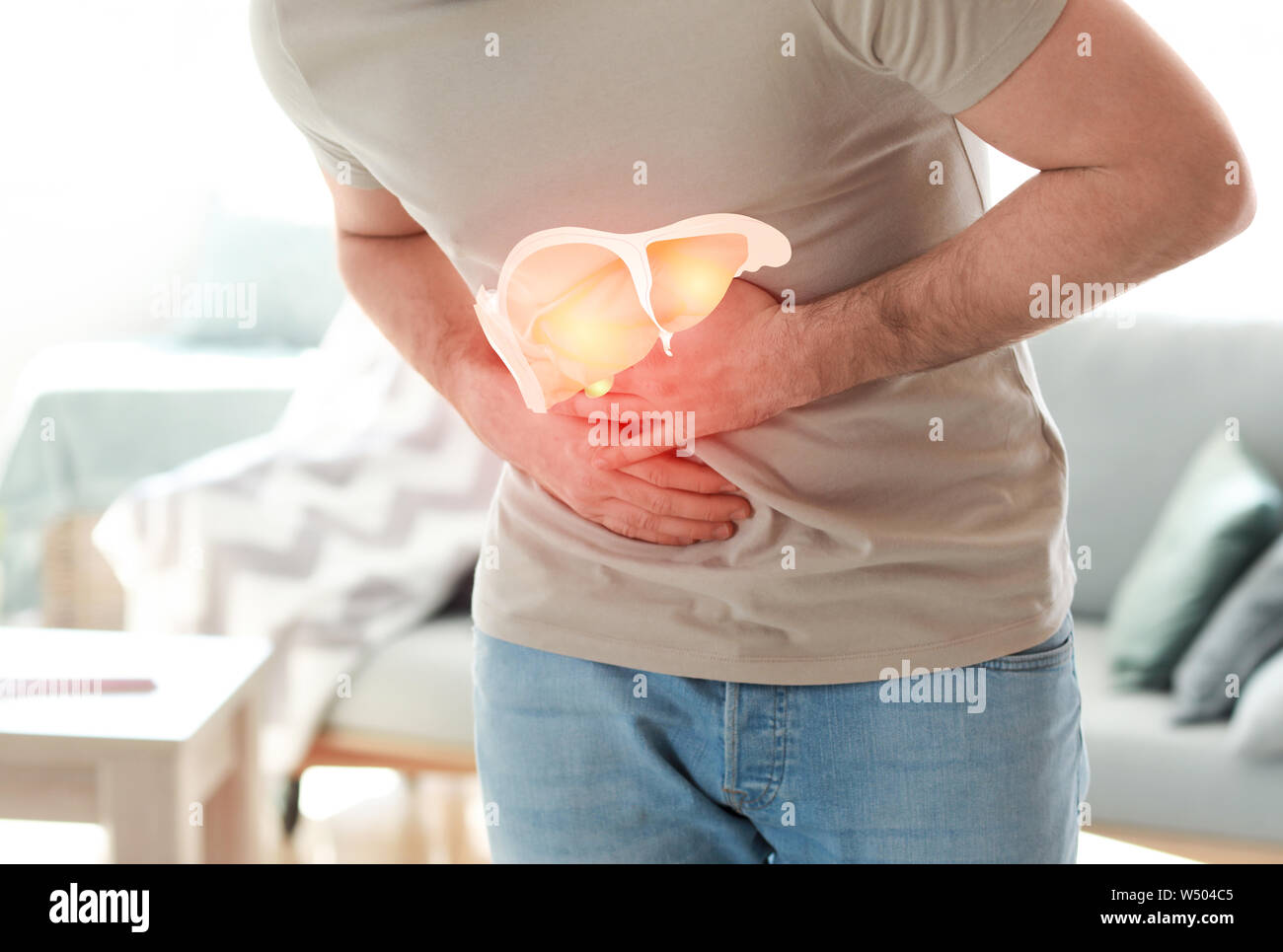 Giovane uomo che soffre di dolore nel fegato a casa, primo piano Foto Stock