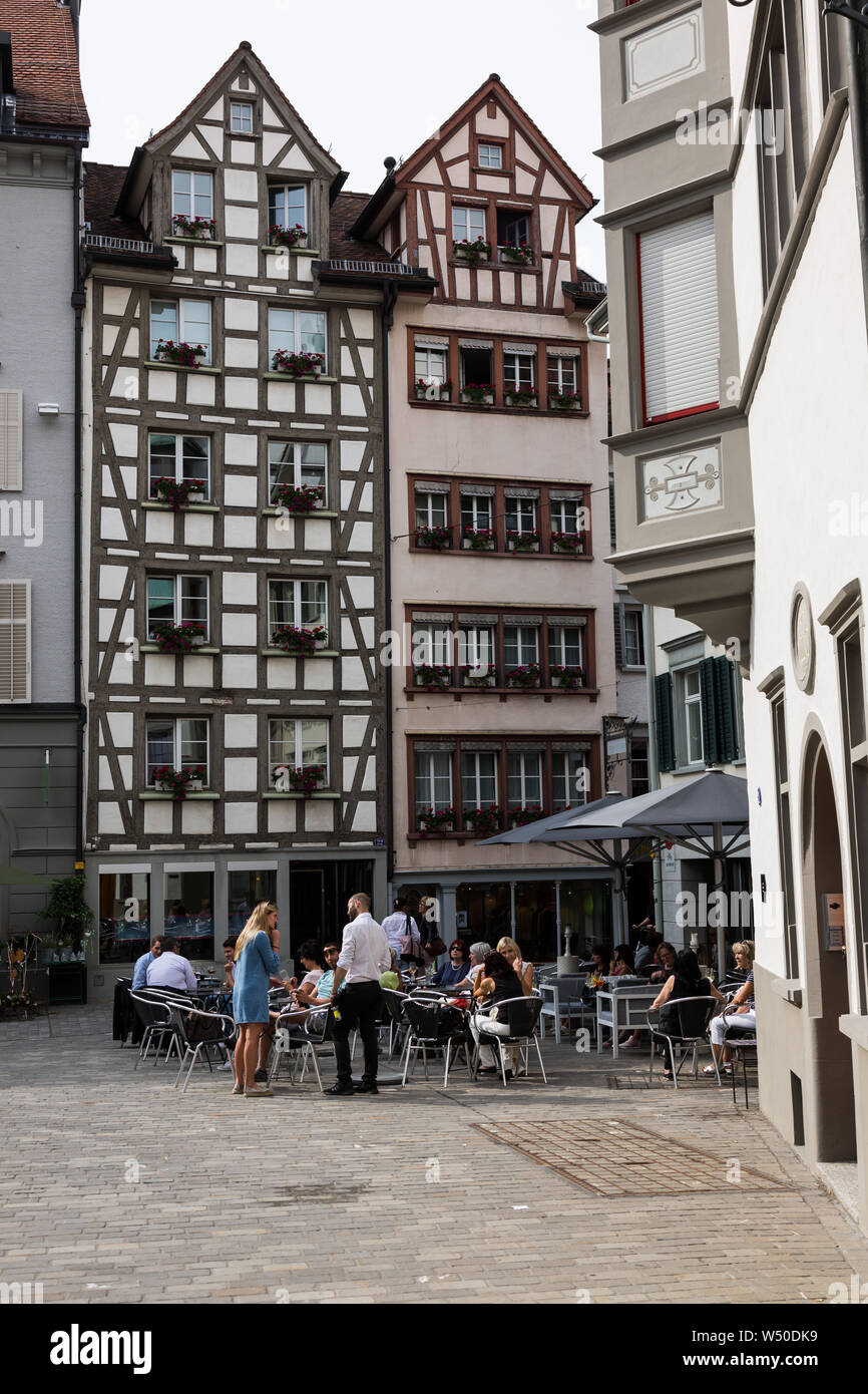 I clienti seduti fuori in una calda giornata svizzera di San Gallo della cittá vecchia. Foto Stock